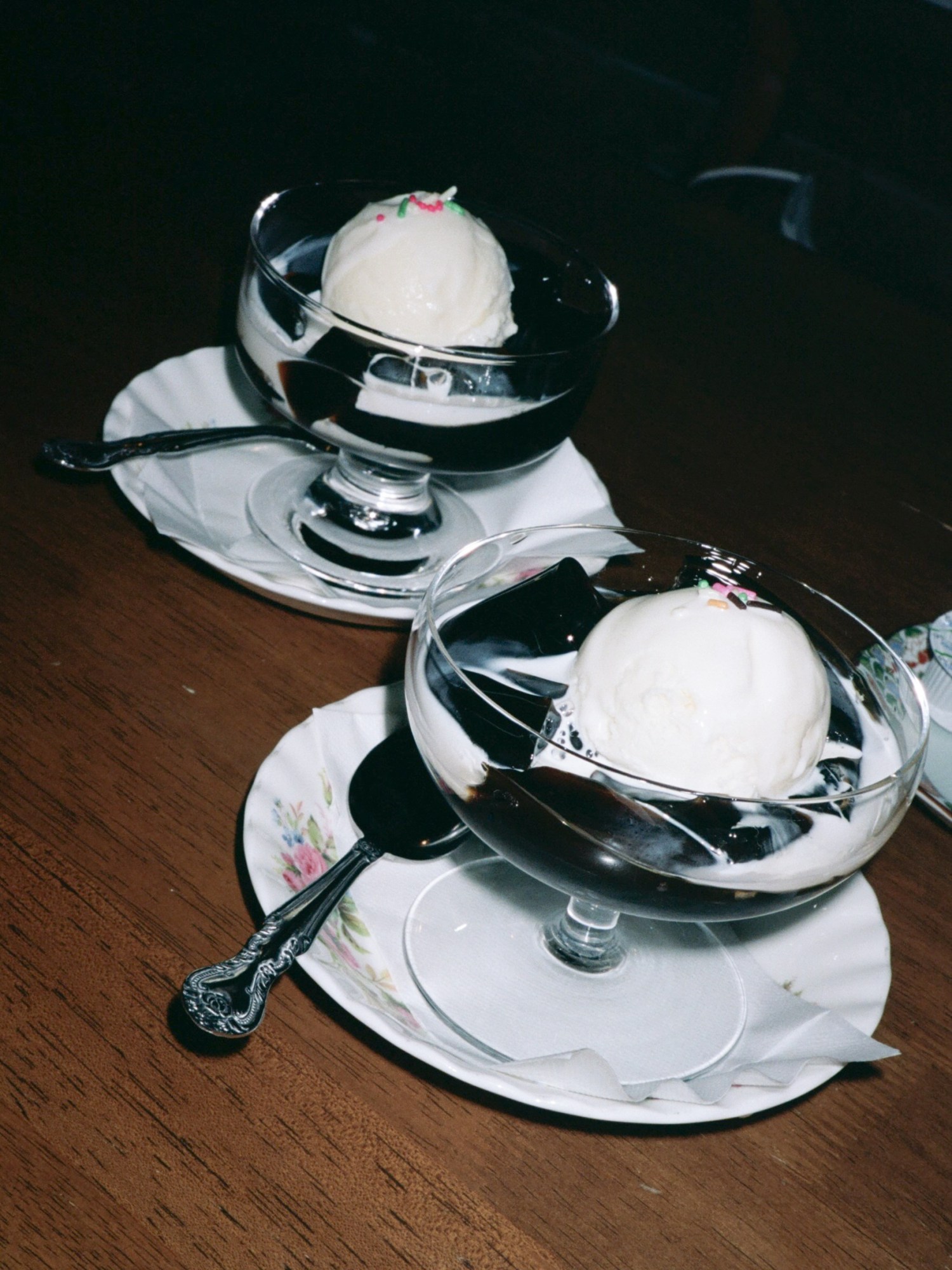 two ice cream sundaes in glass dishes