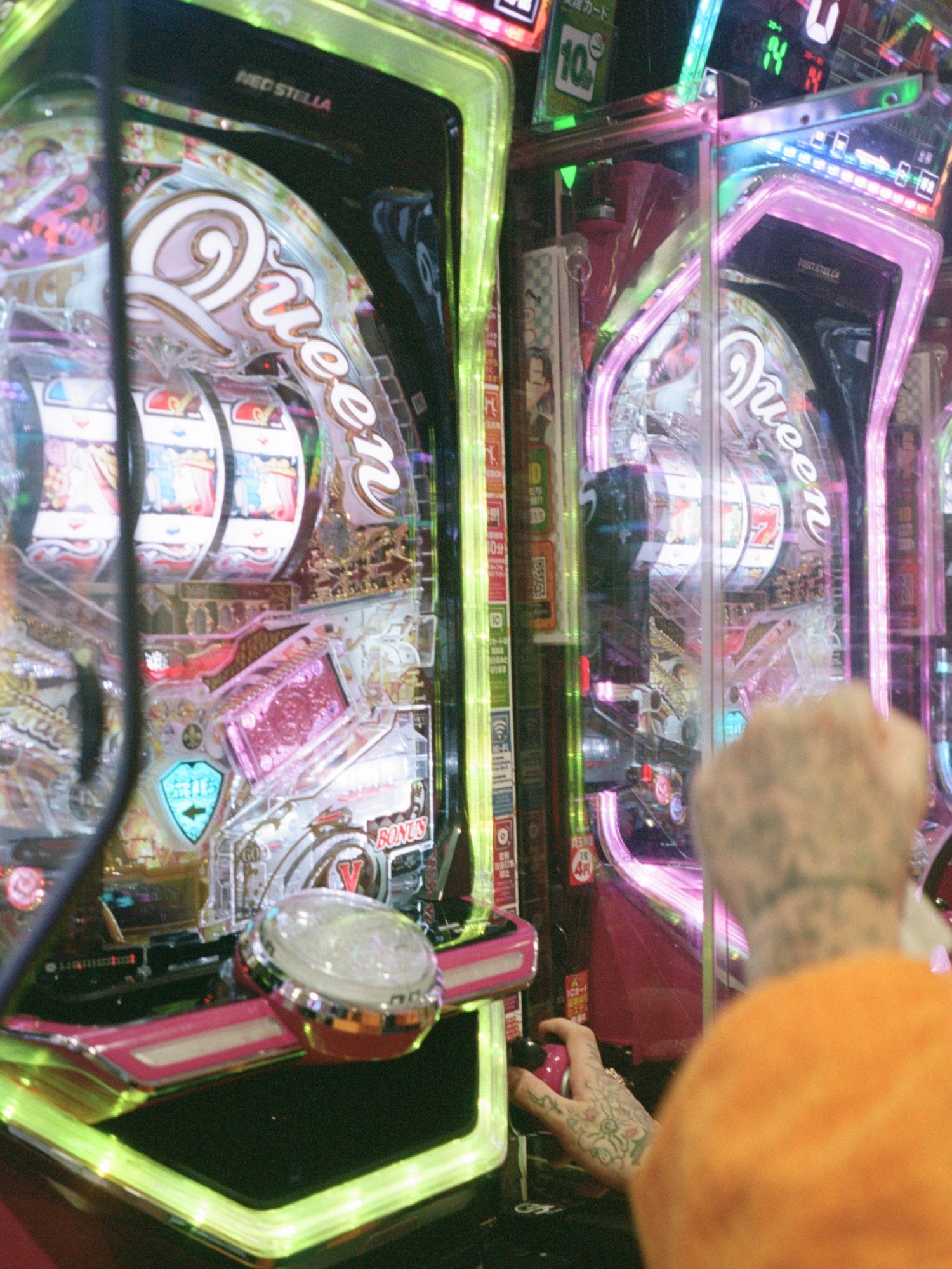 a tattooed hand pulling the lever on a neon slot machine