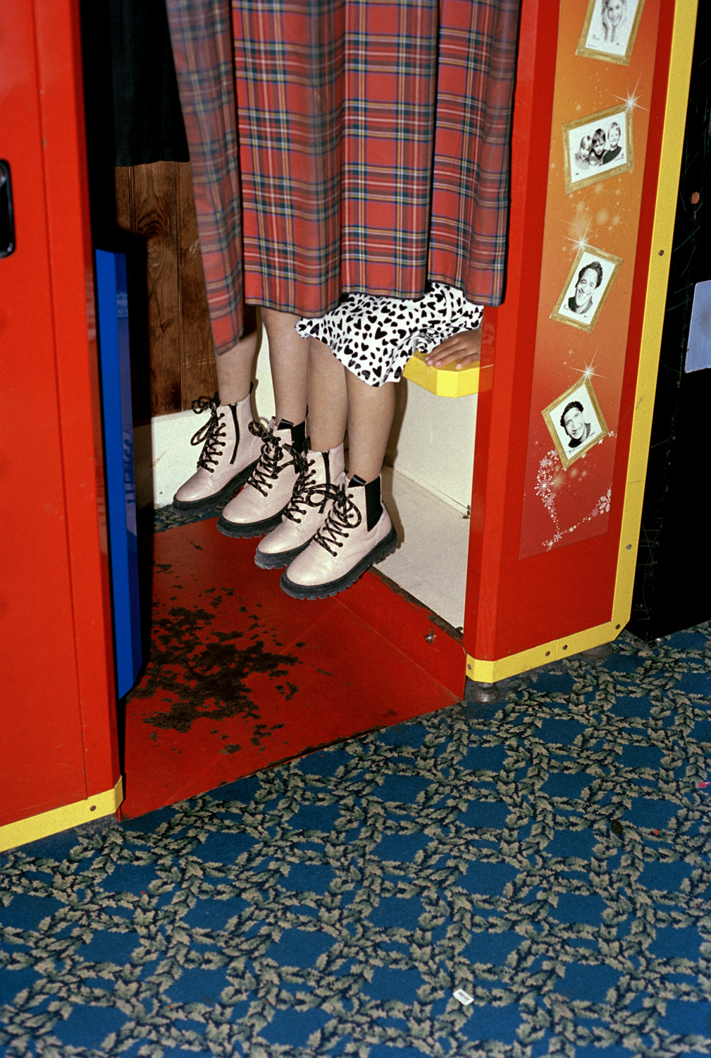 legs with boots poking out of a colorful photo booth