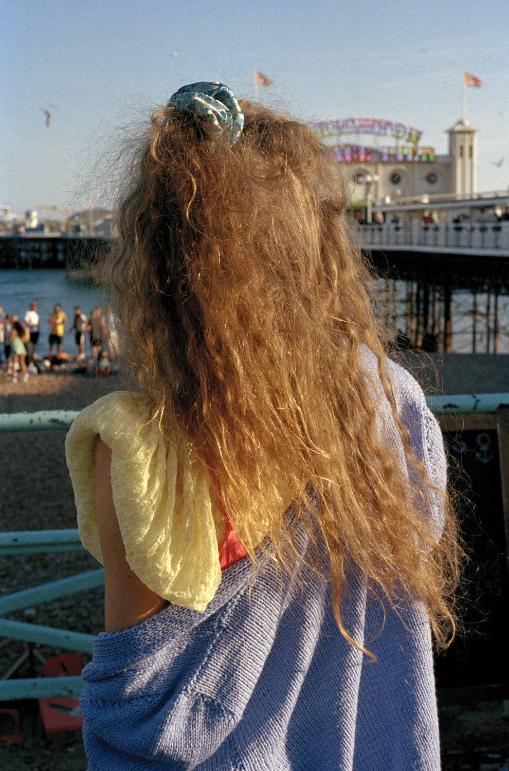 the back of a girl with red hair standing on the pier