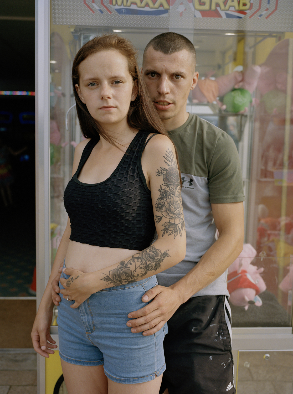 a couple posing in front of an arcade