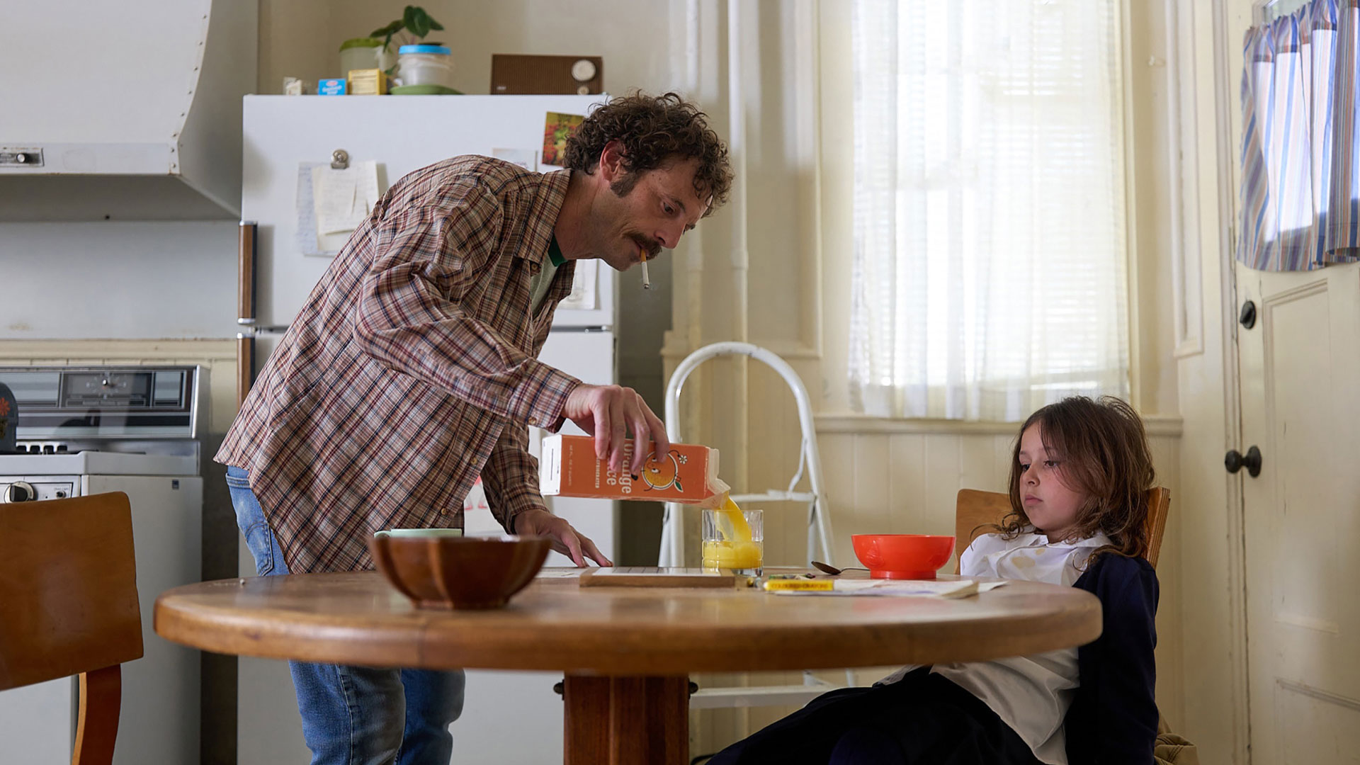 a man serves his young daughter breakfast in fairyland movie