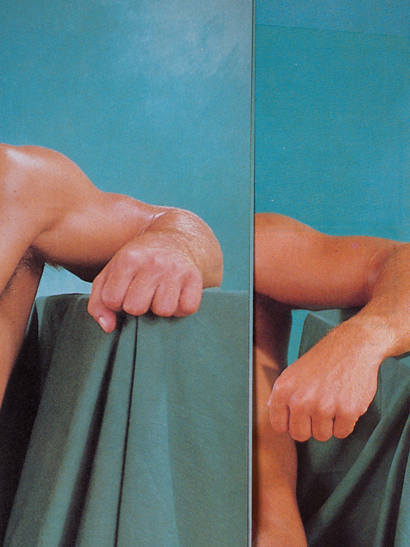 a close up of a muscular arm resting on a blue fabric-draped podium