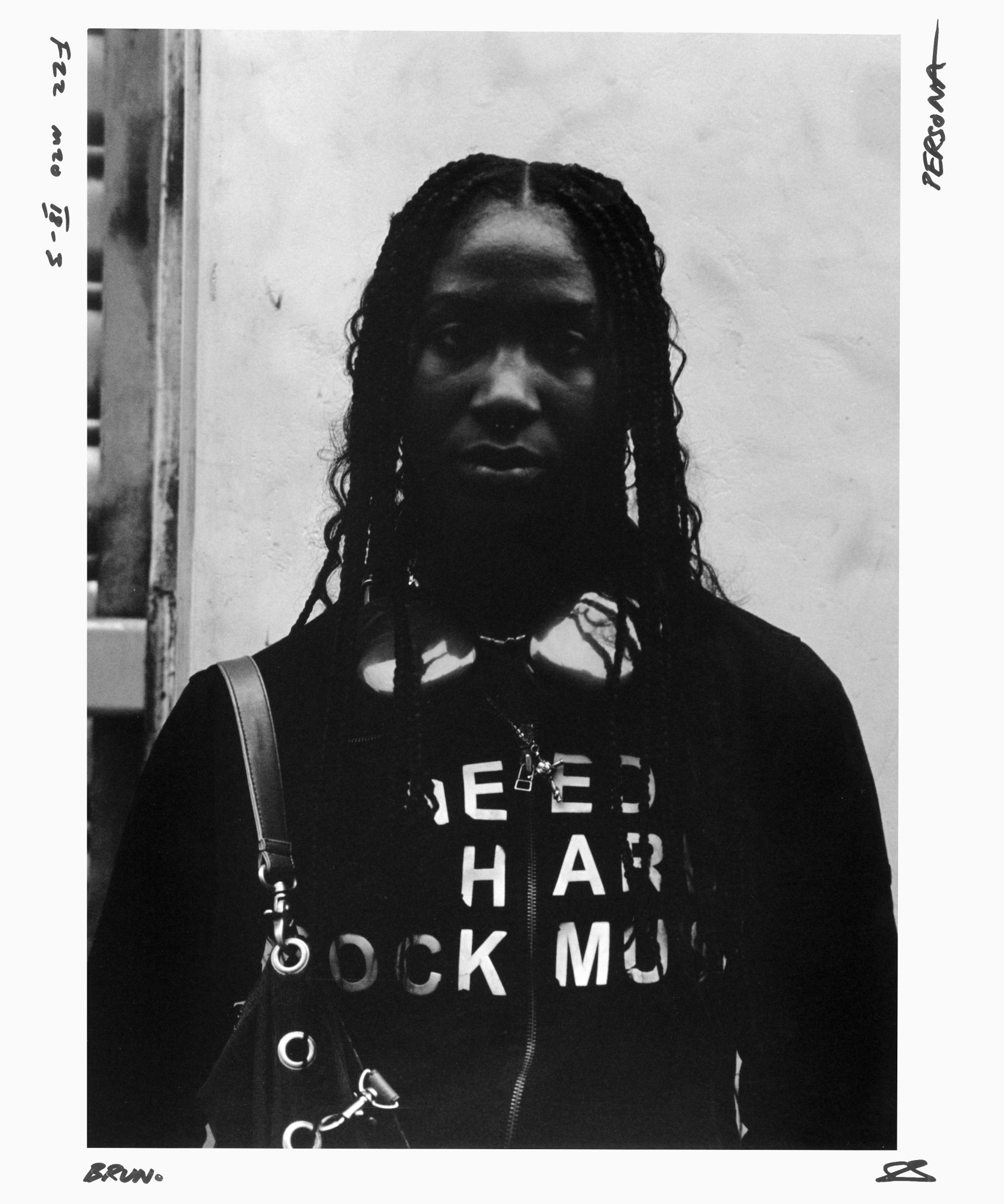 black-and-white portrait of a young person in a black hoodie with white lettering