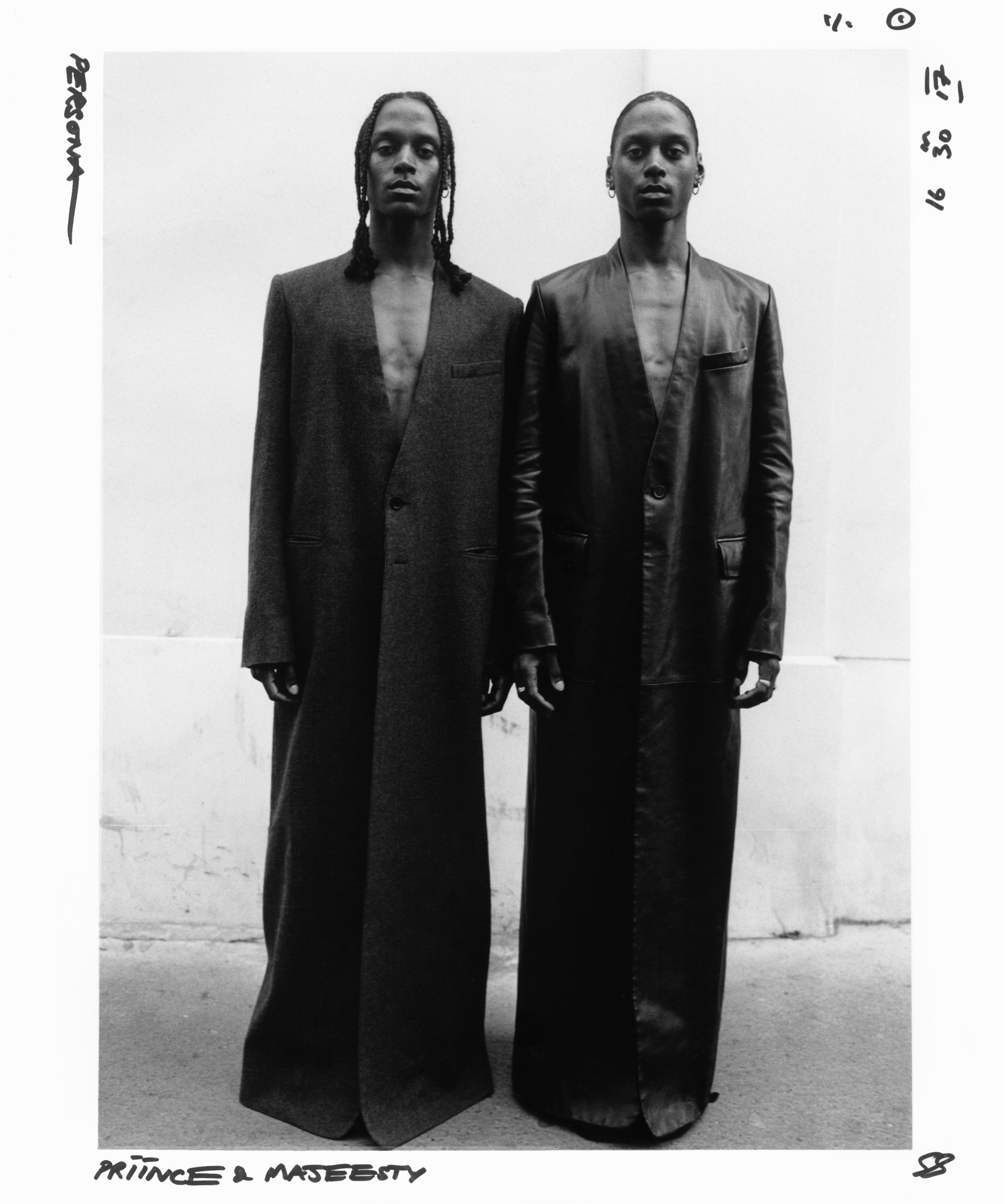 black-and-white image of two people dressed in floor length leather coats standing side by side