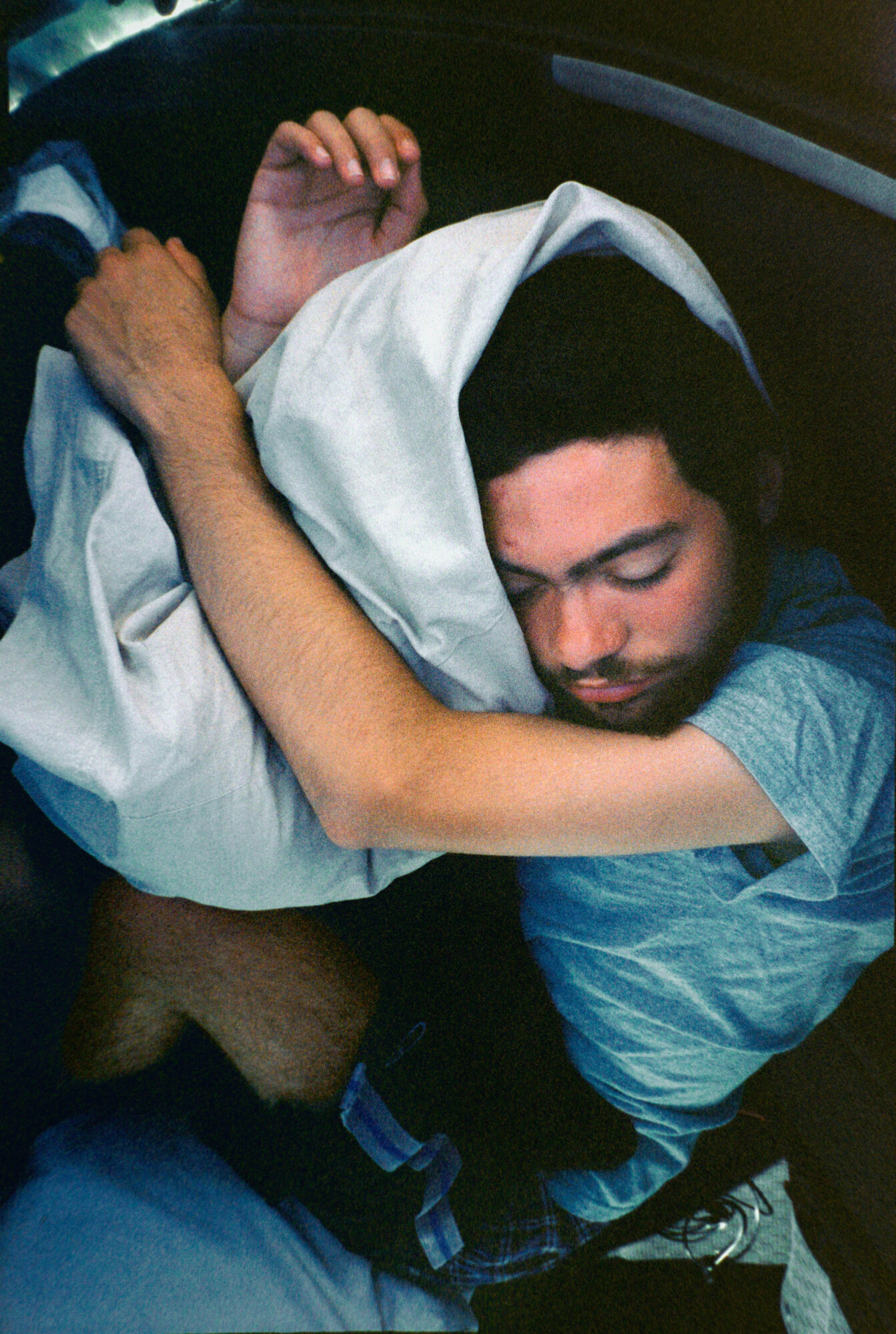 a guy sleeping on a pillow curled up