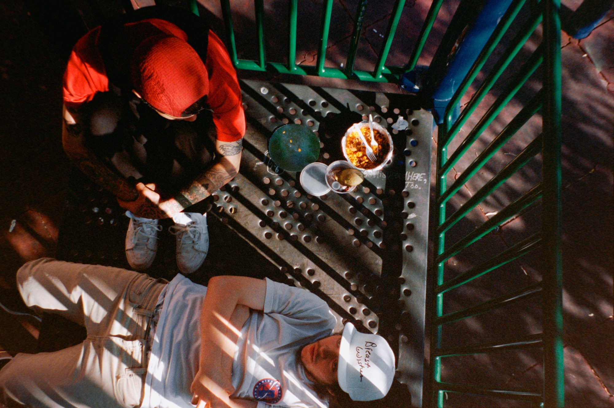 two people sitting and lying on a new york fire escape