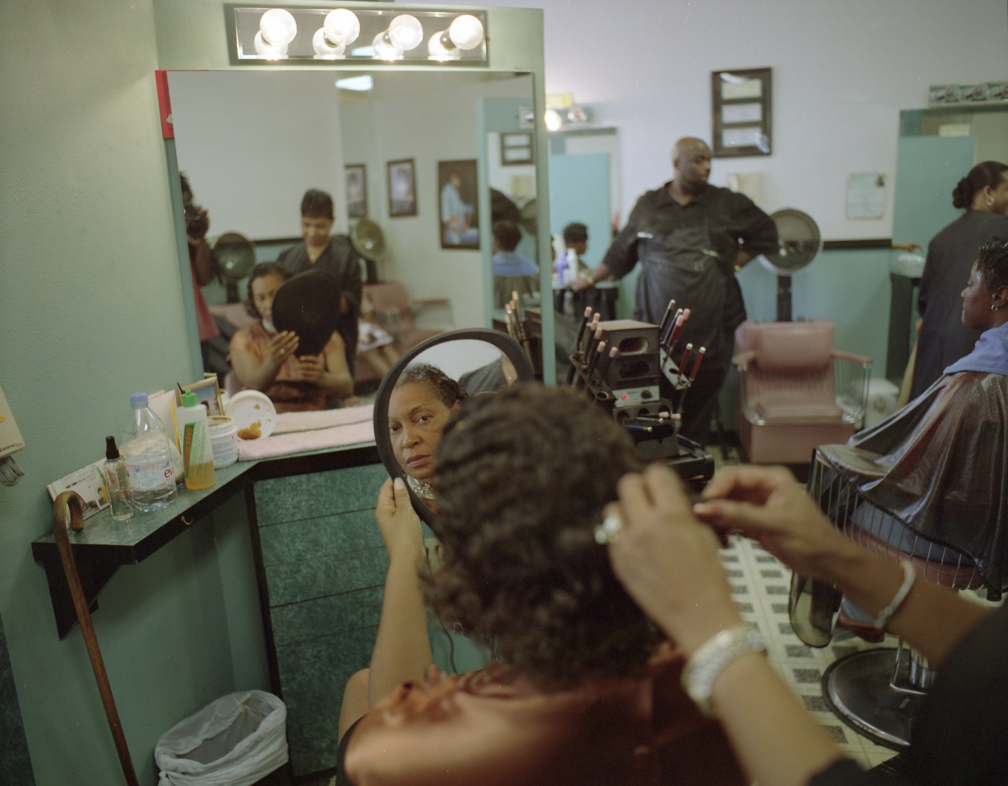 A woman having her hair done at a Black hair salon.