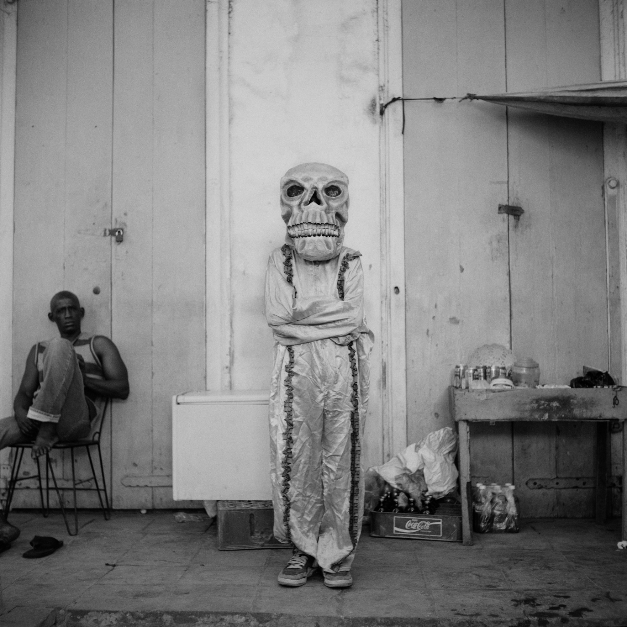 A festival goer wearing a white satin skeleton costume.