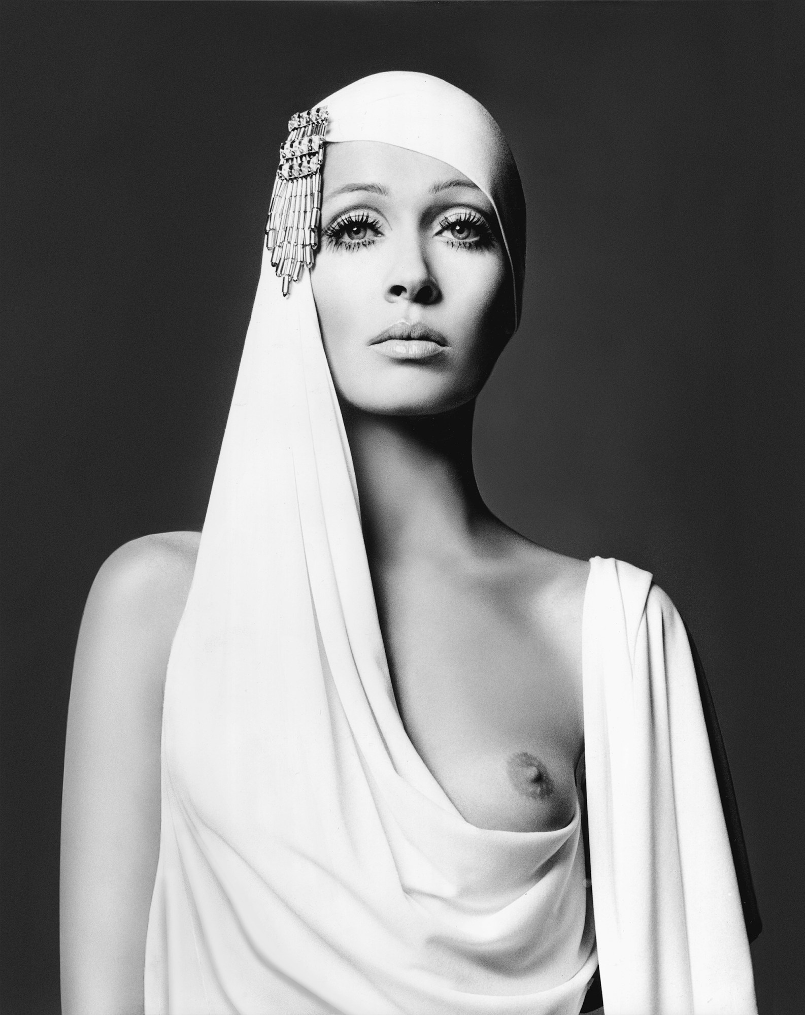 black-and-white image of a woman in white draped toga covering one of her breasts