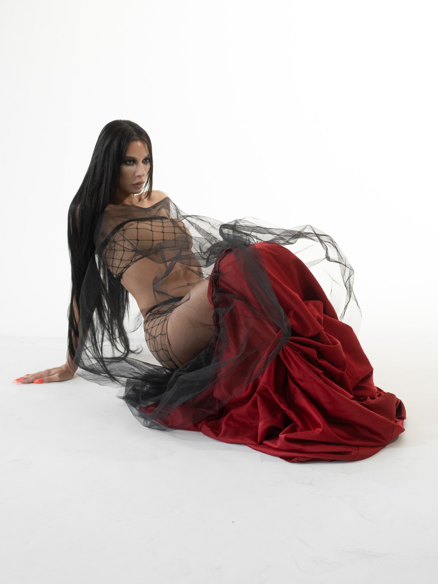 a model pressing herself up from the floor in a red anna bolina skirt and top