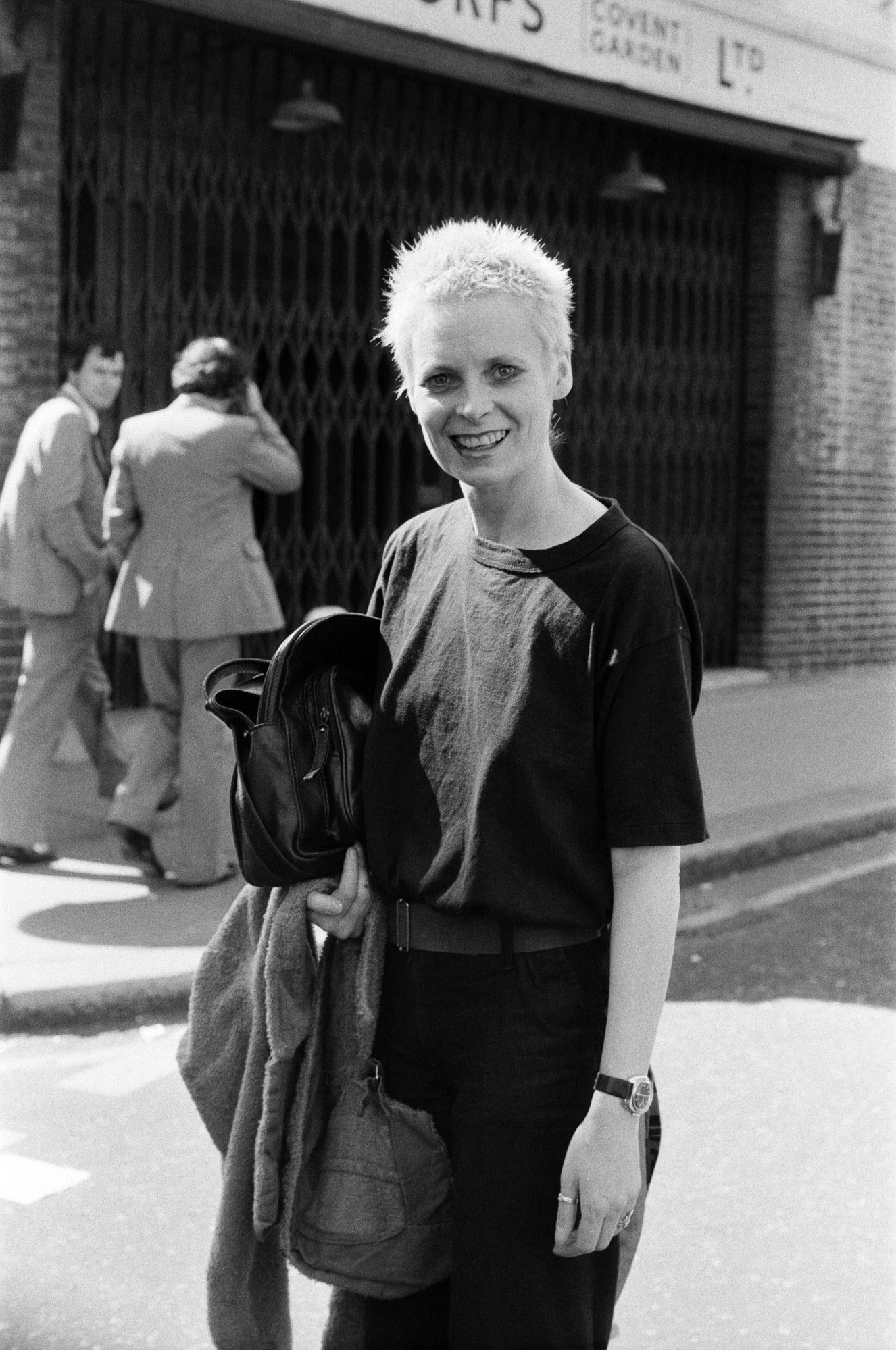 young vivienne westwood with a bleached pixie cut standing in the street