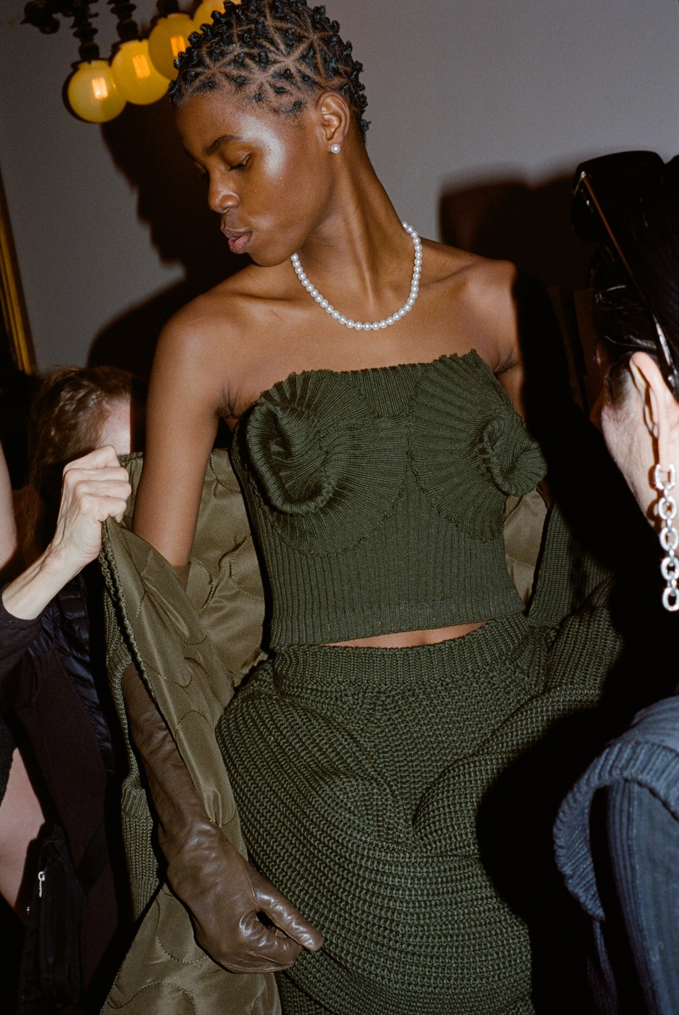 a model in a green wool two piece has her coat adjusted backstage at marc jacobs AW23