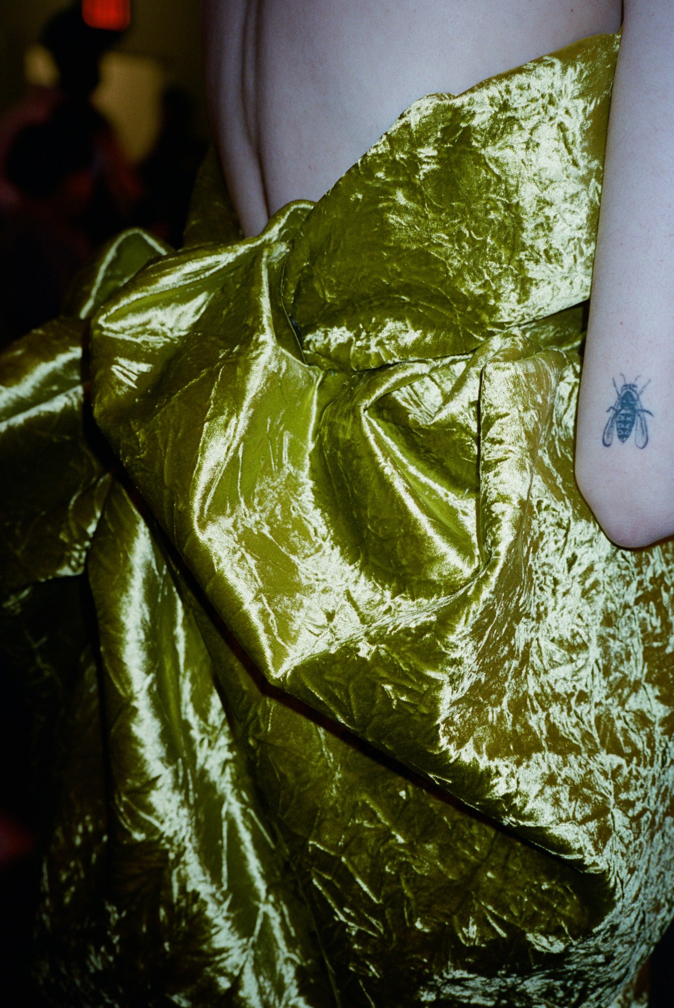 a model in a gold lame dress shot from behind up close backstage at marc jacobs aw23