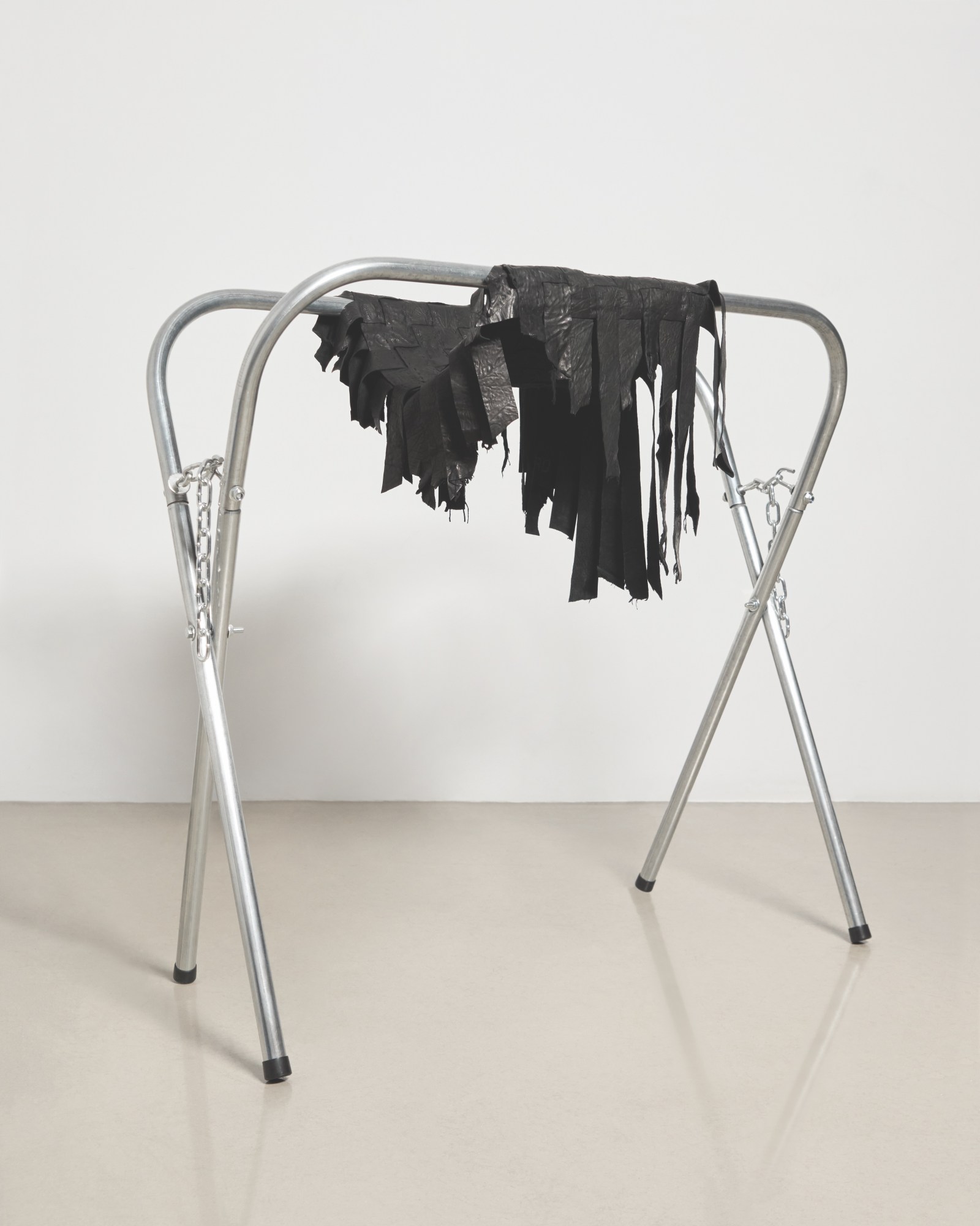 Hand-cut and stitched leather draped over an auto-body repair stand.