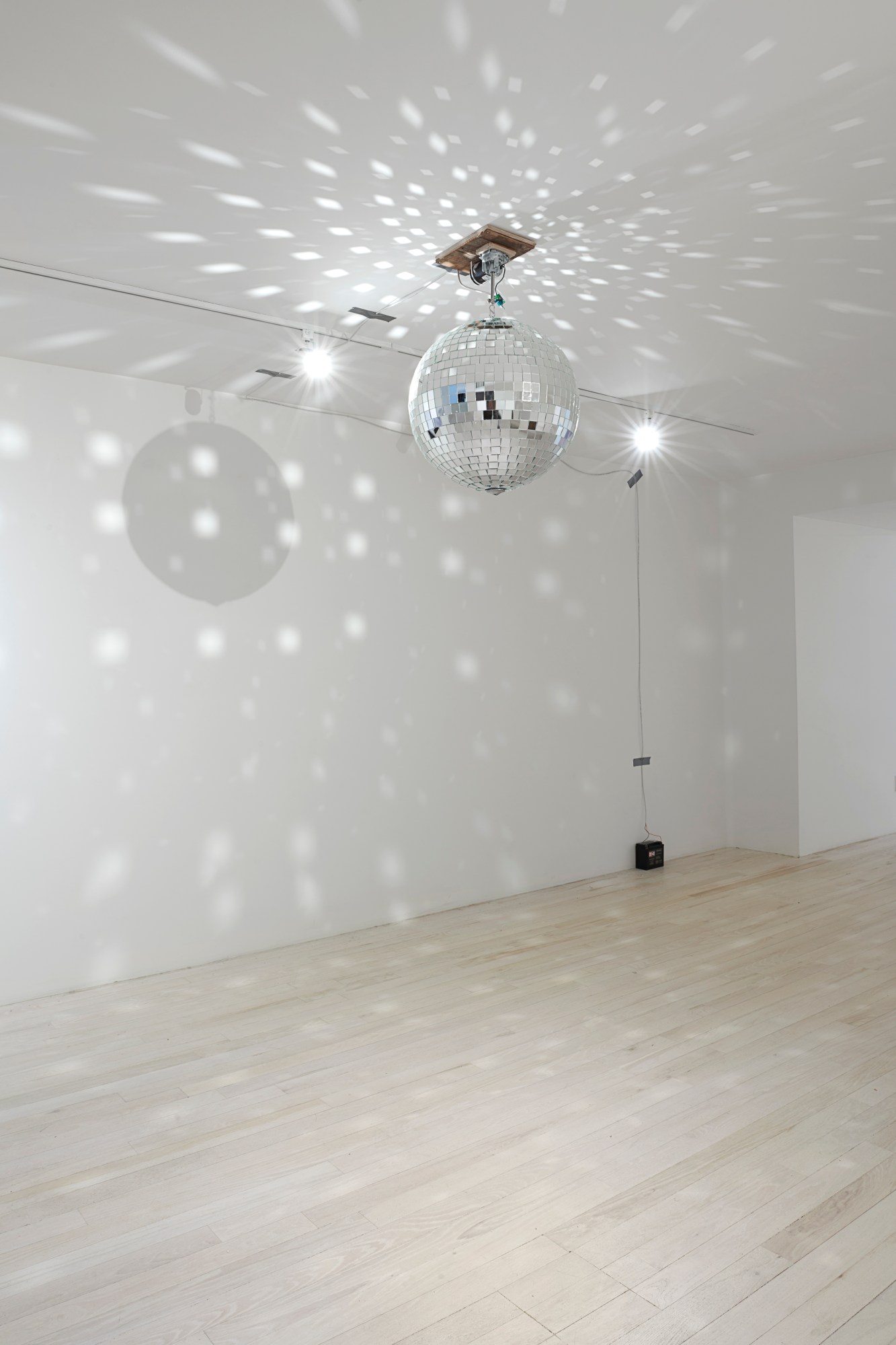 A disco ball shining on a white wall