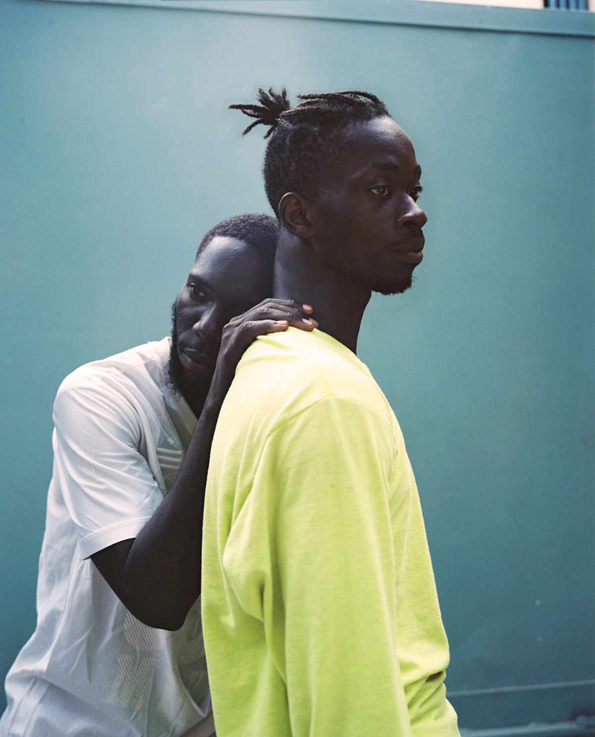 a couple embracing in front of a blue wall