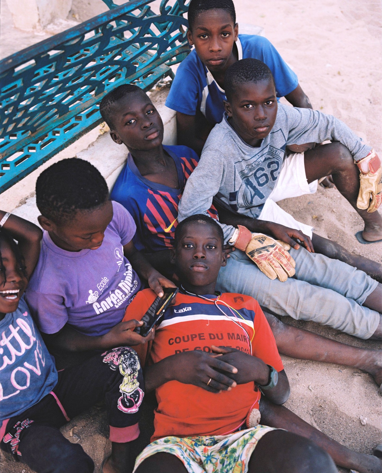 a group of young senegalese boys sitting together in the sand