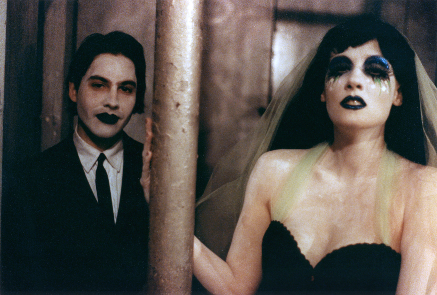 Twinkle and Love Forever; two people in formal dress with white makeup and black lips