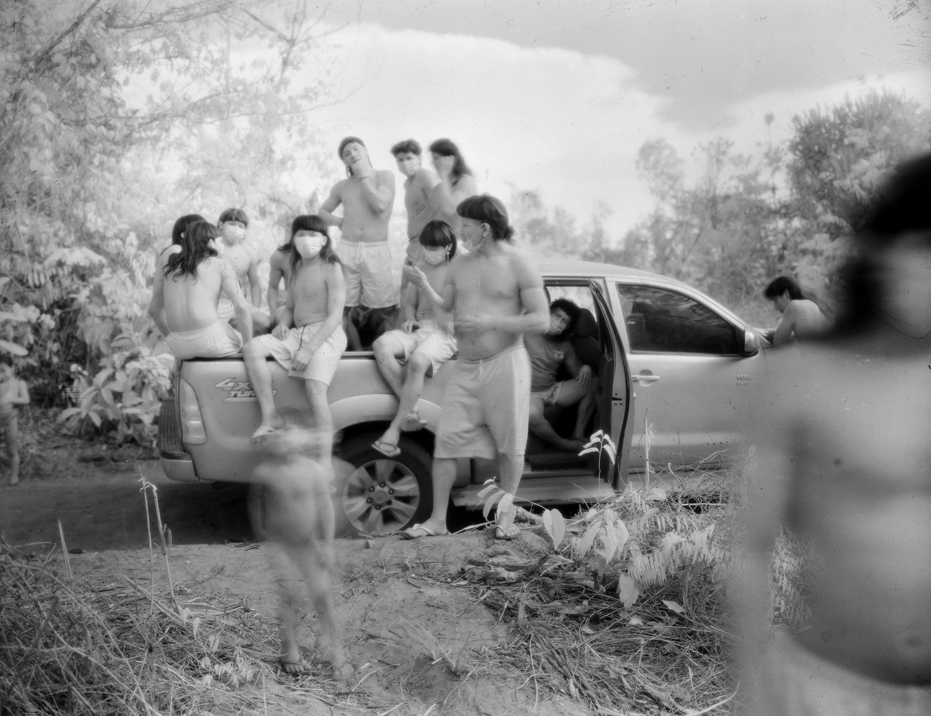 Photograph from Richard Mosse's immersive video artwork Broken Spectre of a group of local people sat in the boot of a car