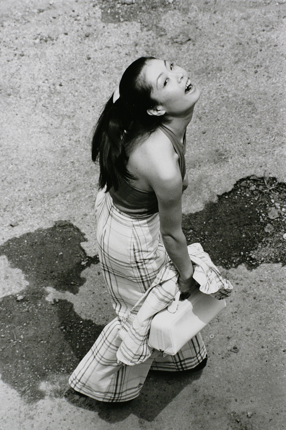 yoko looking up with her mouth open in plaid pants in tokyo by masahisa fukase