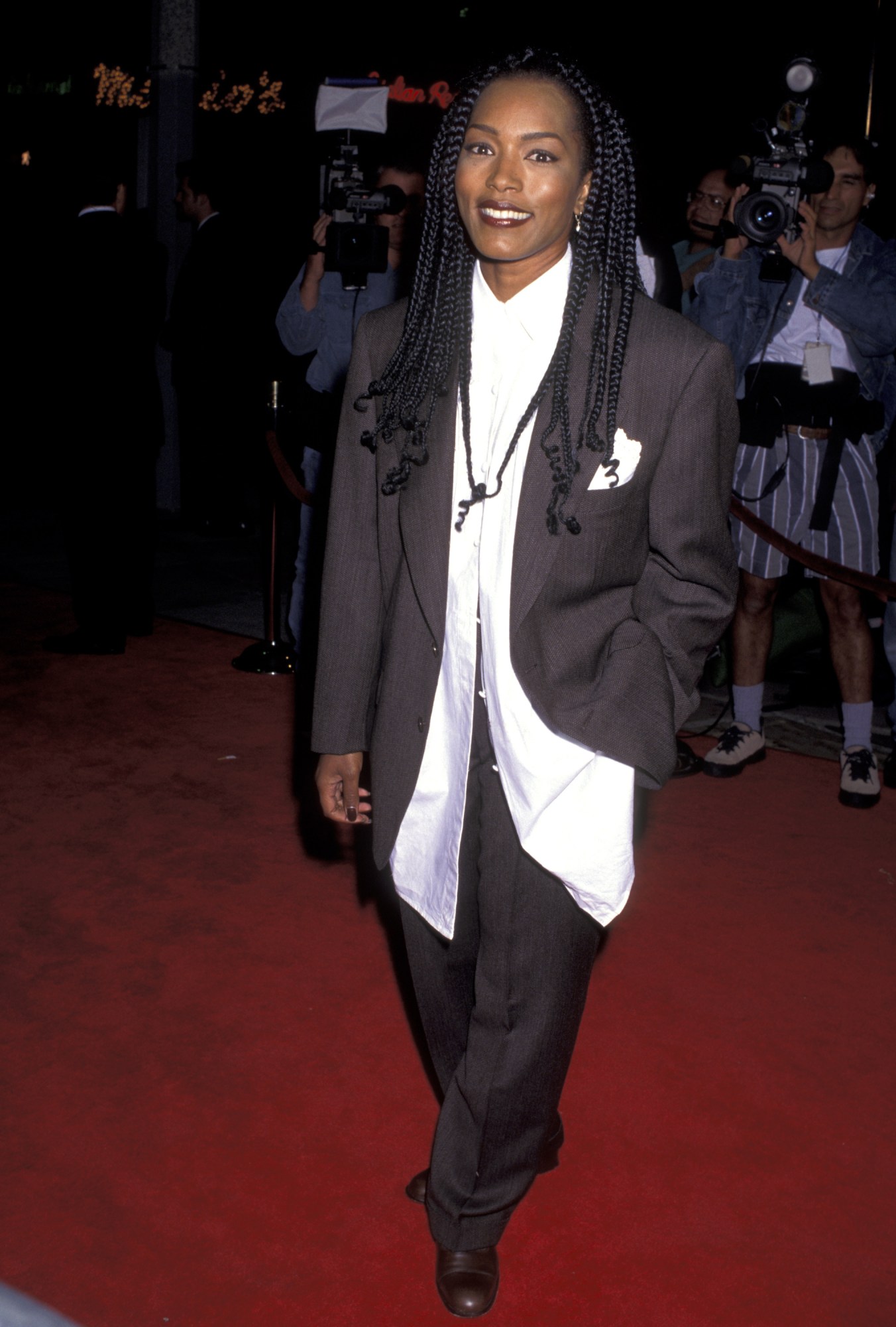 angela bassett on the red carpet wearing an oversized charcoal suit at the strange days premiere 1995