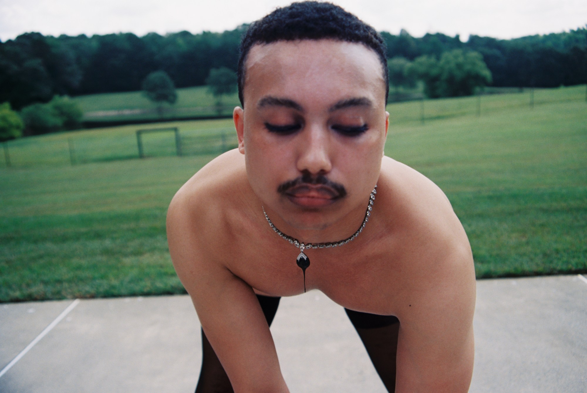 A young person wearing a silver necklace posing for the camera