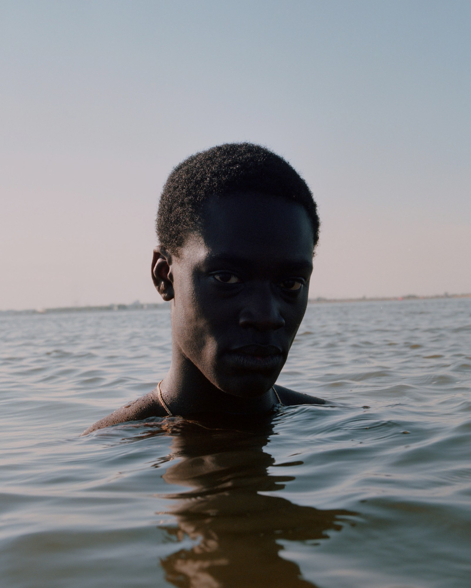 A young man posing for a portrait in the ocean