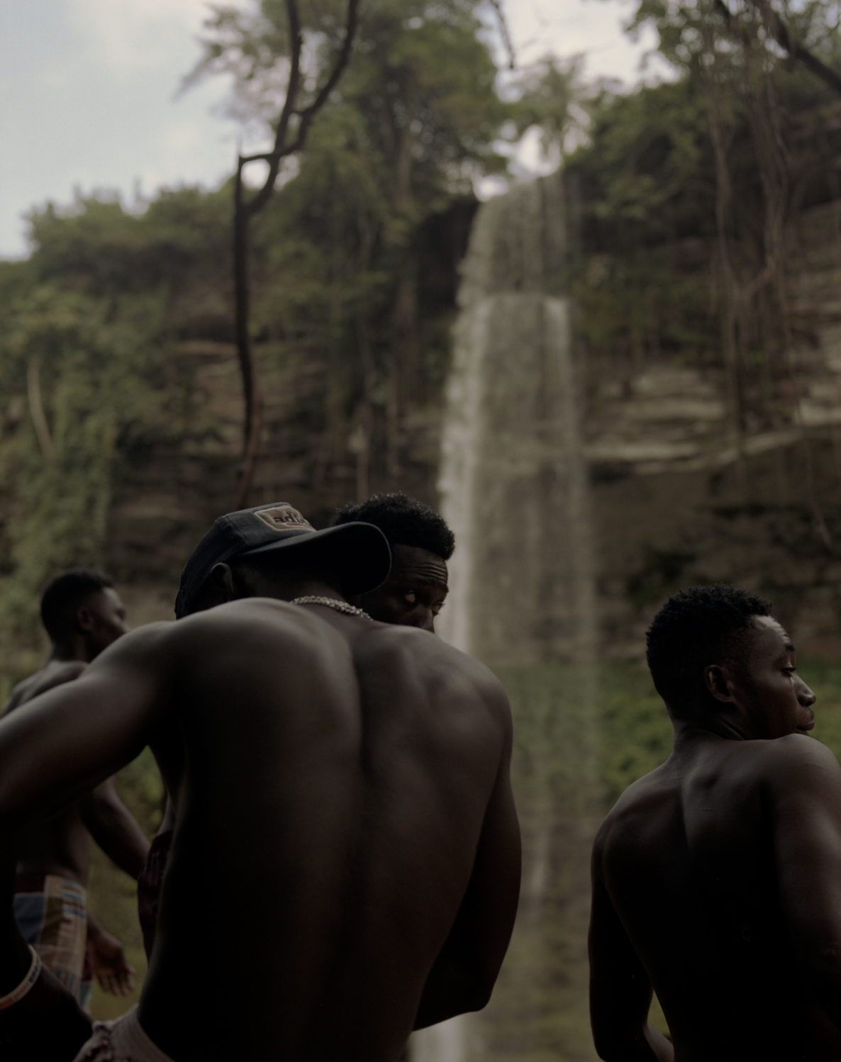 Young men standing near a waterfall