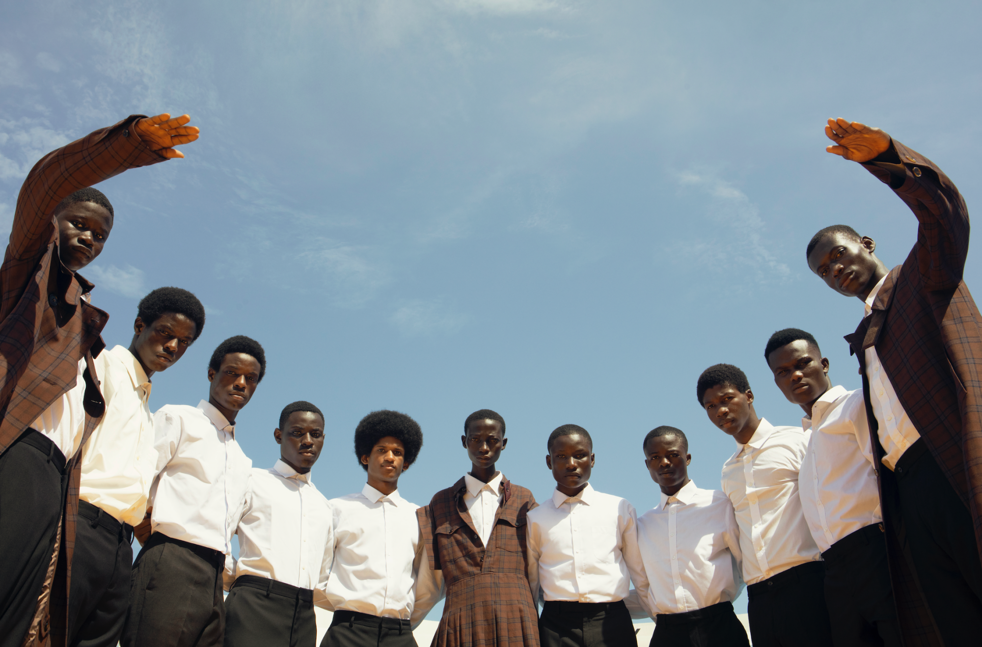 Young men posed in crisp white shirts in a semi-circle