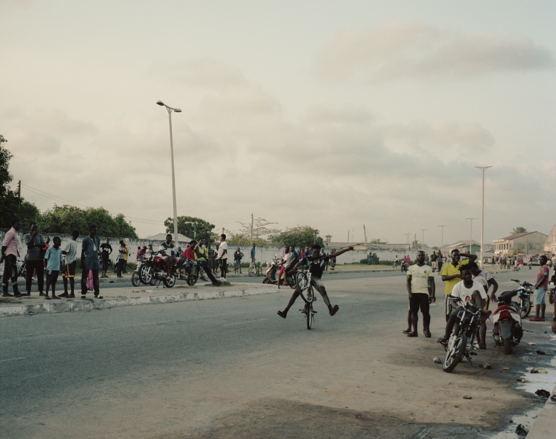 A crowd watching young men ride bicycles in Ghana