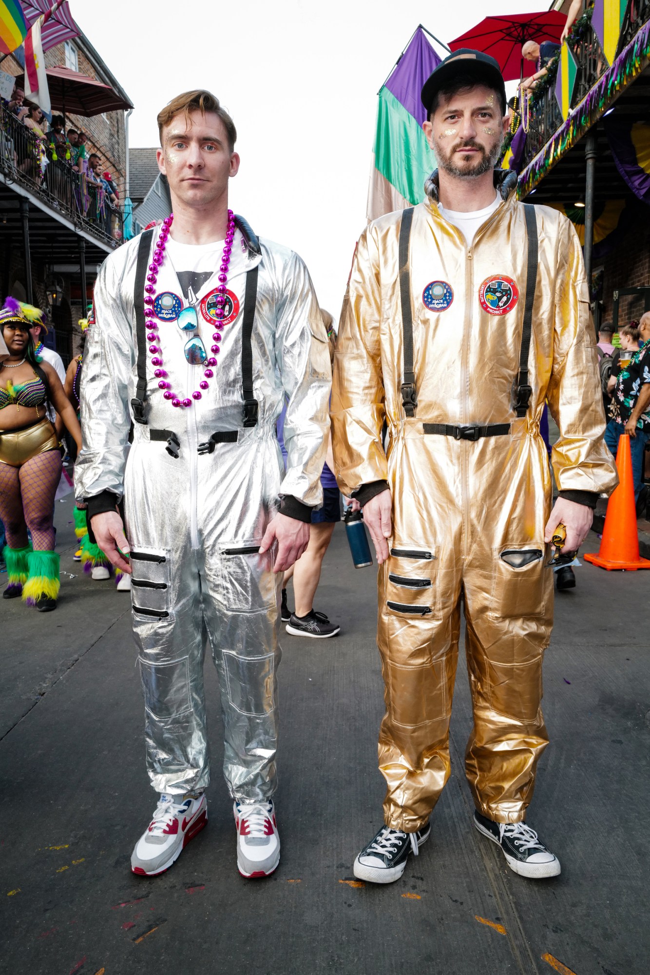 Photograph by Tom TBow Bowden of two men dressed in metallic astronaut costumes, trainers and glitter at a pride event