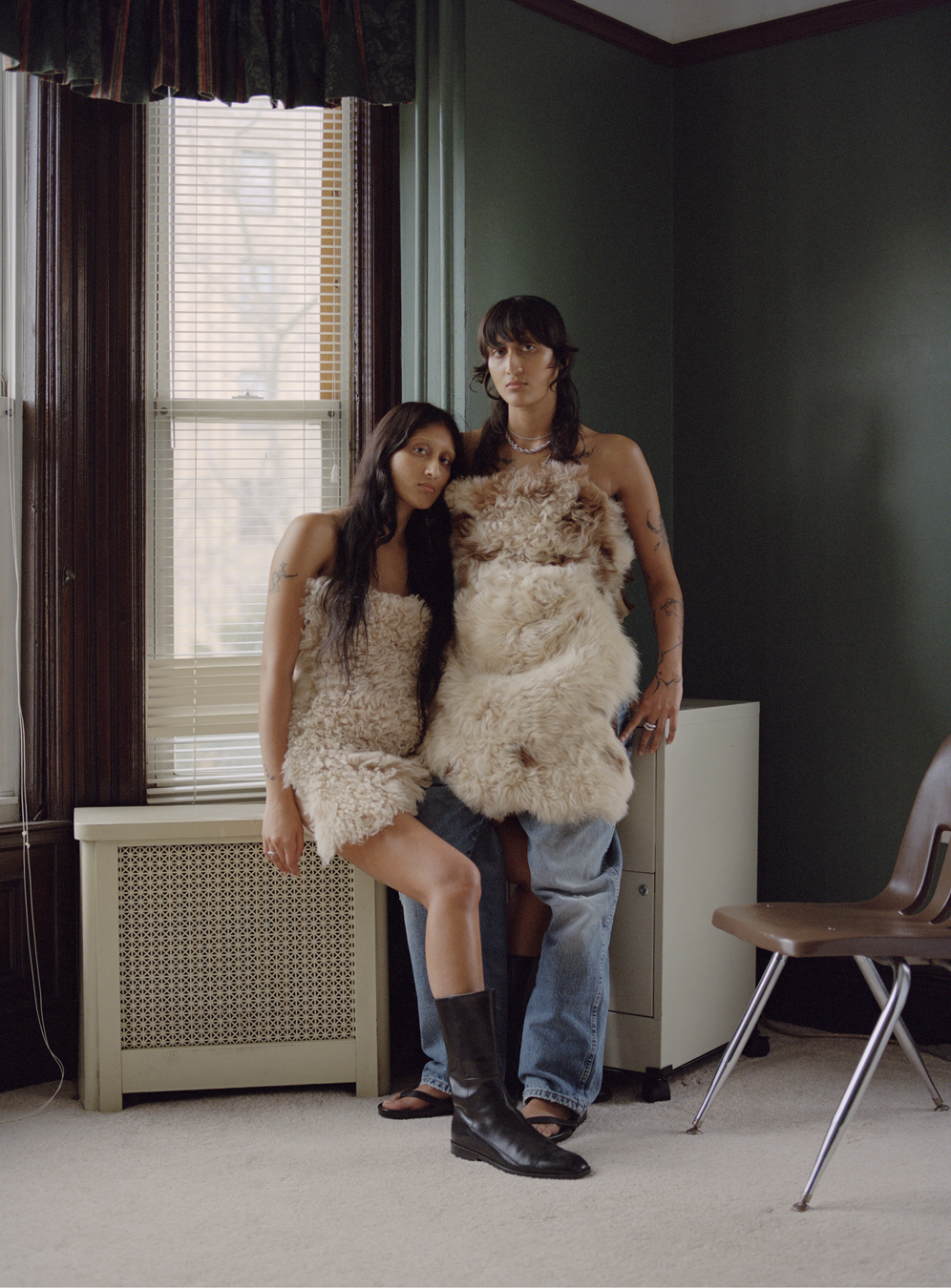 Two models sitting in an office space wears jeans and fluffy dresses by Ponte in a photograph by Deirdre Lewis in i-D’s The Timeless Issue, no. 371, Spring 2023