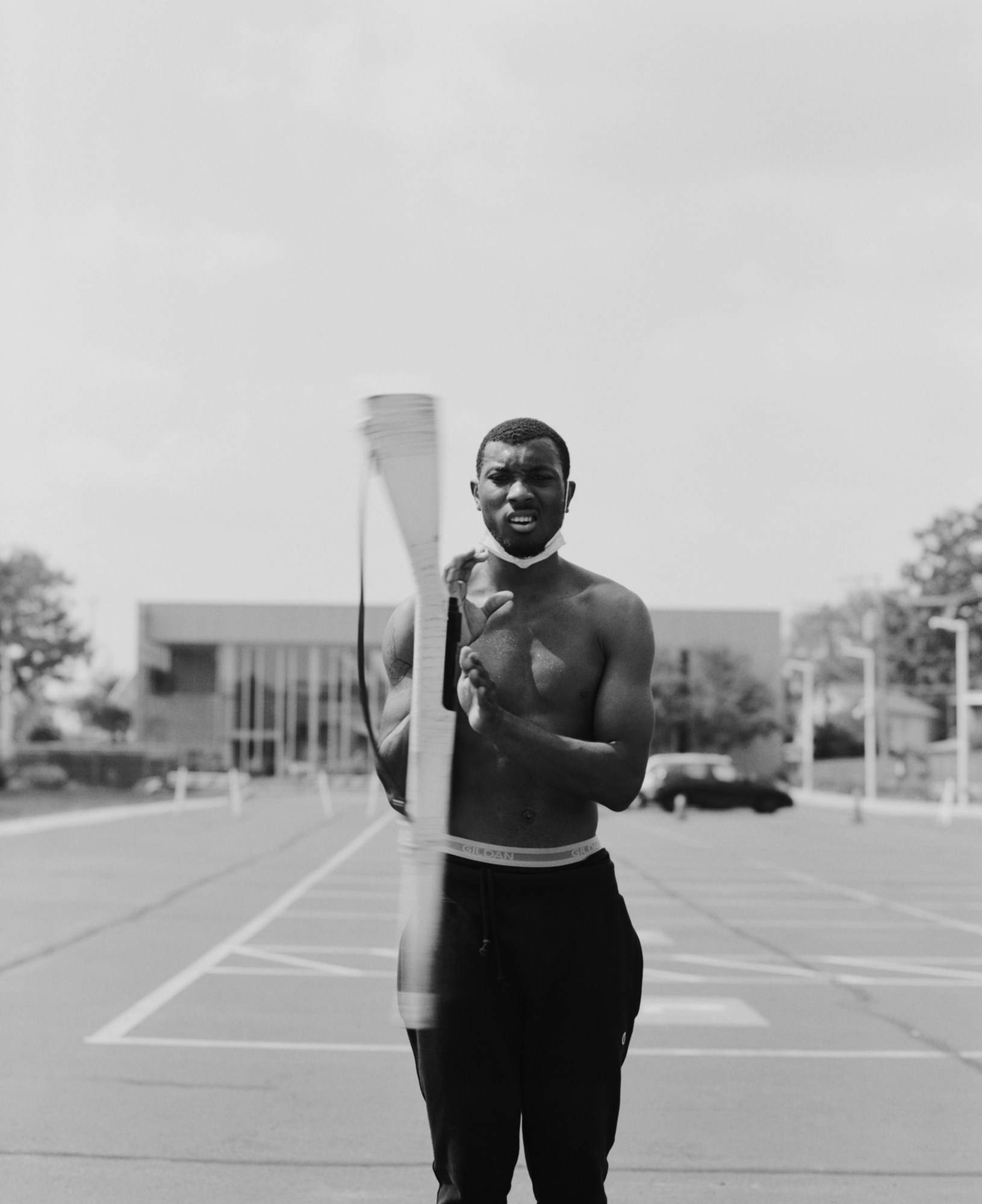 Black-and-white photo of man twirling gun as part of Chicago's South Shore Drill Team