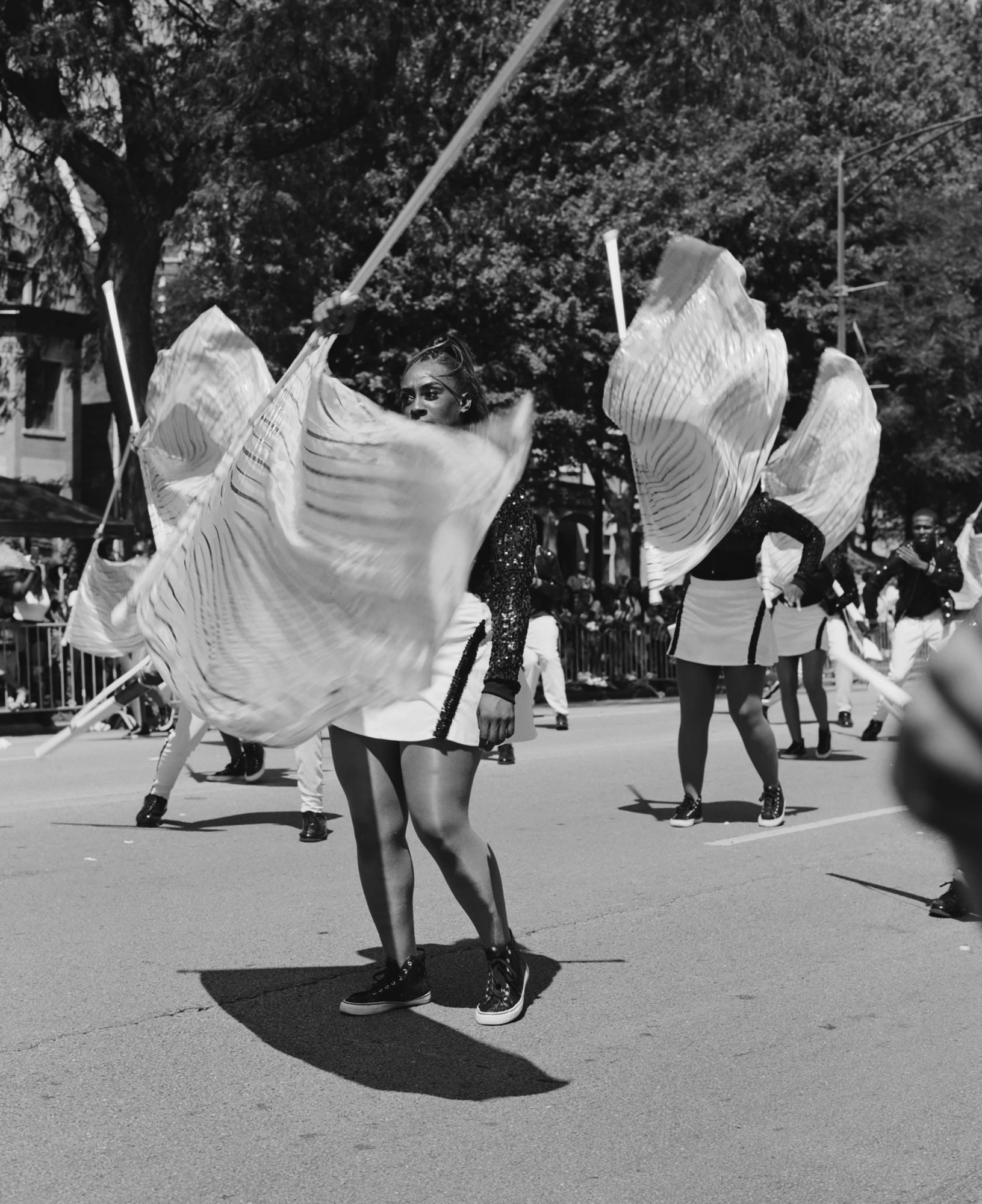 Black-and-white photo of women twirling flags as part of Chicago's South Shore Drill Team