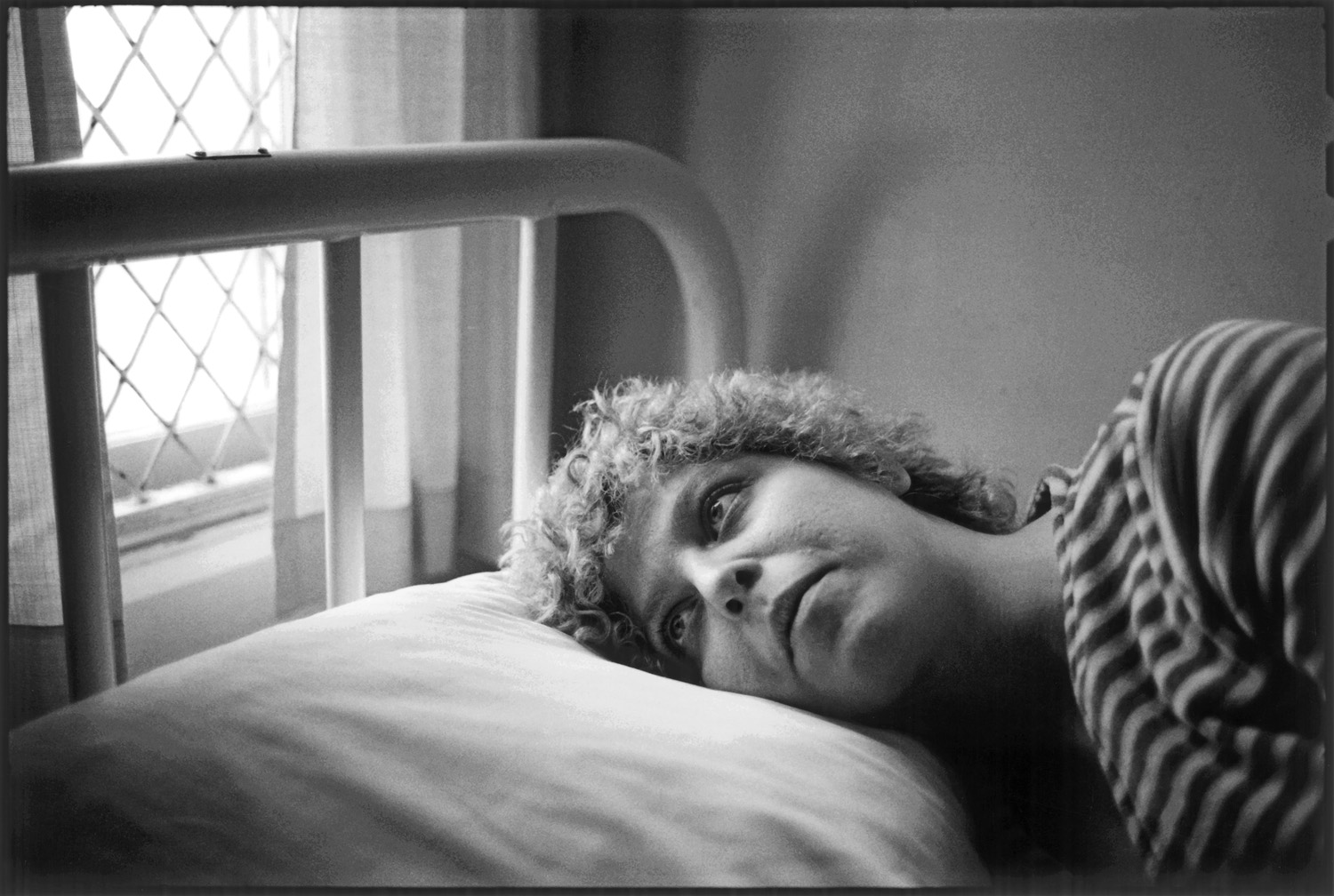 A woman in a striped shirt lying on a white pillow