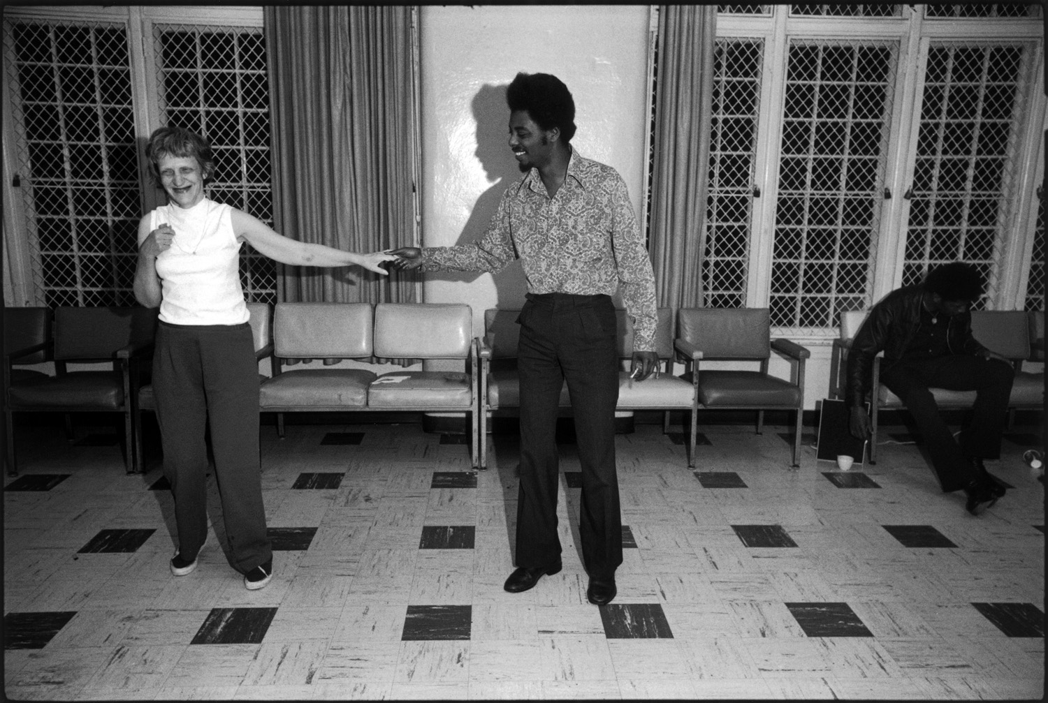 A woman dancing with a man on checkered tile