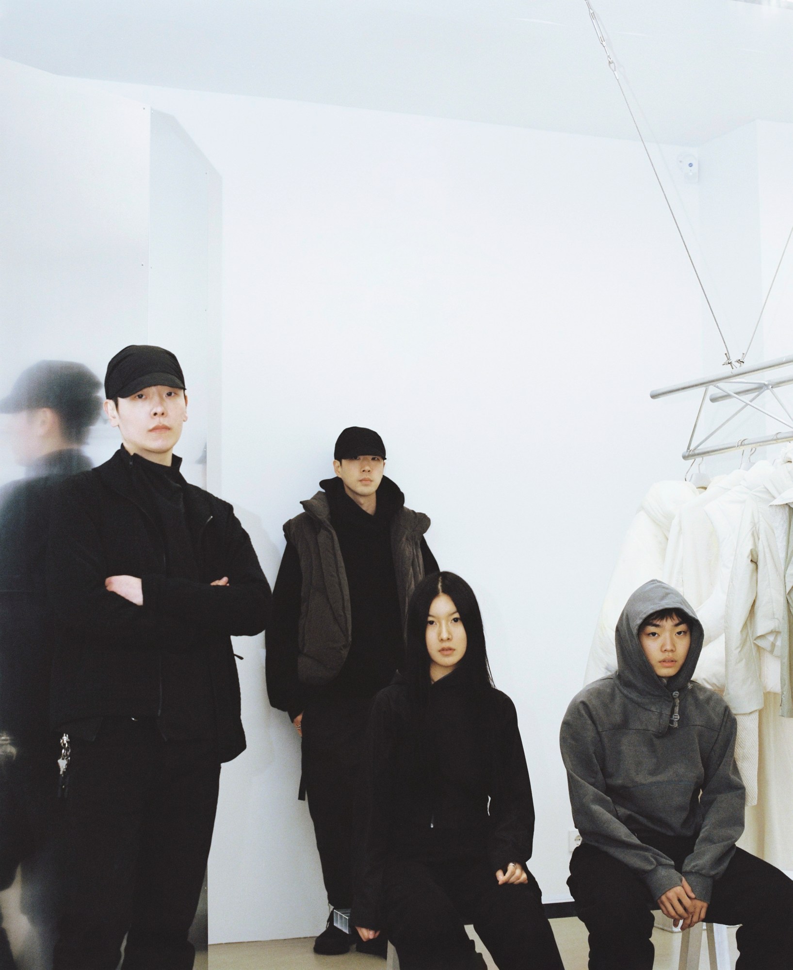 four designers wearing dark stylish clothes stare blankly into the camera