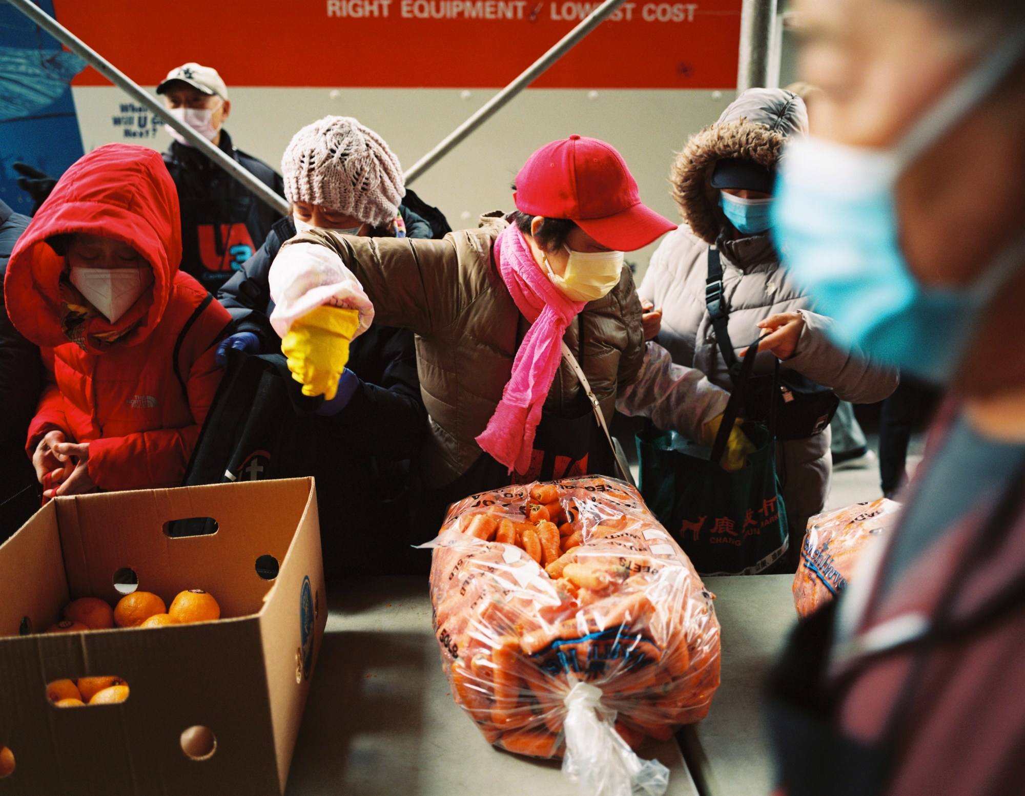 a bag of carrots and produce being distributed in chinatown