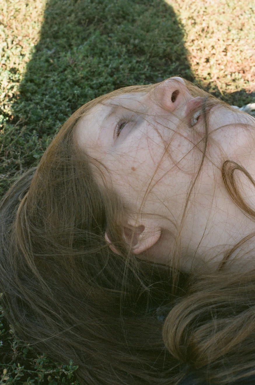 a woman lying on green grass