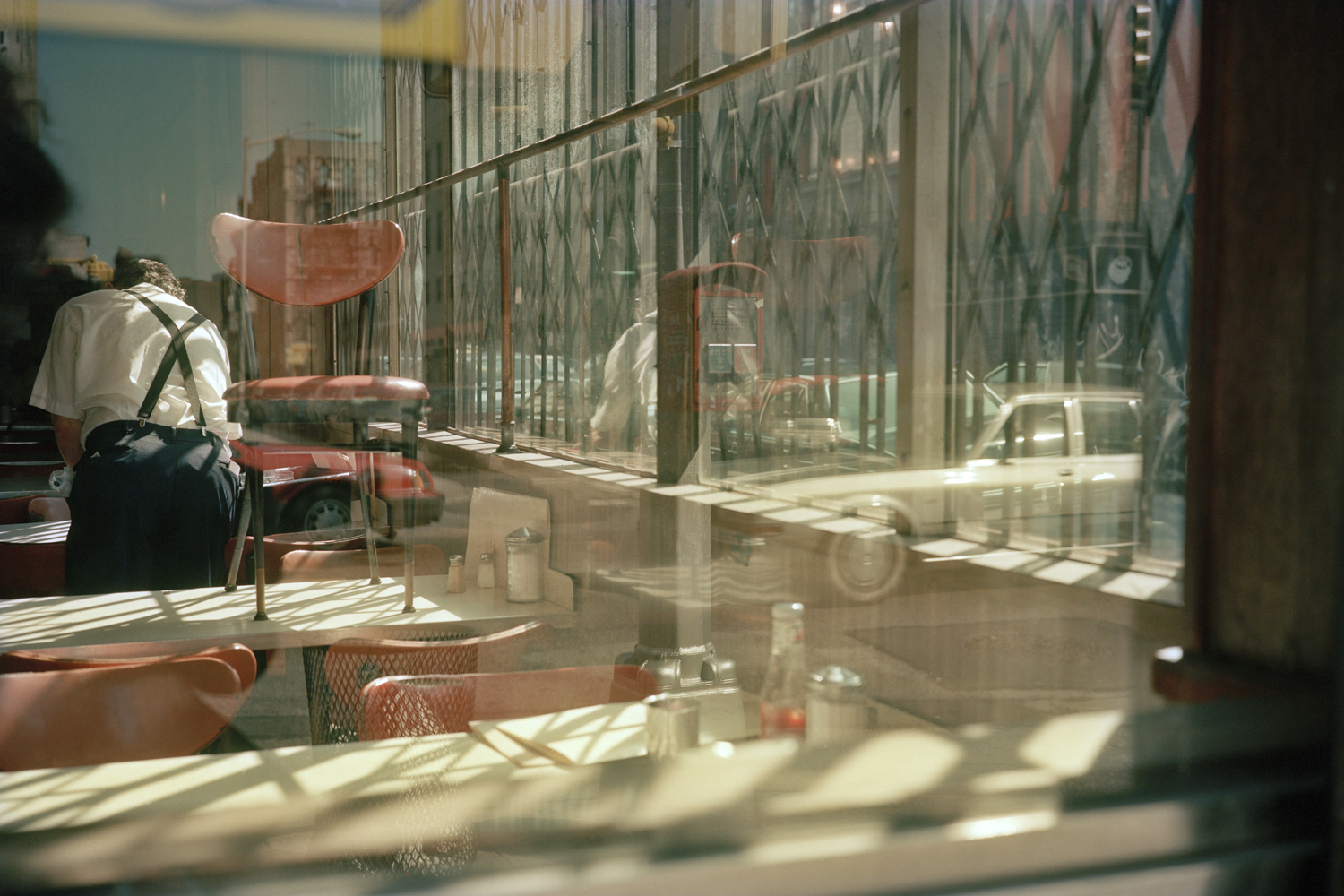 a reflection in the window of a shuttered diner