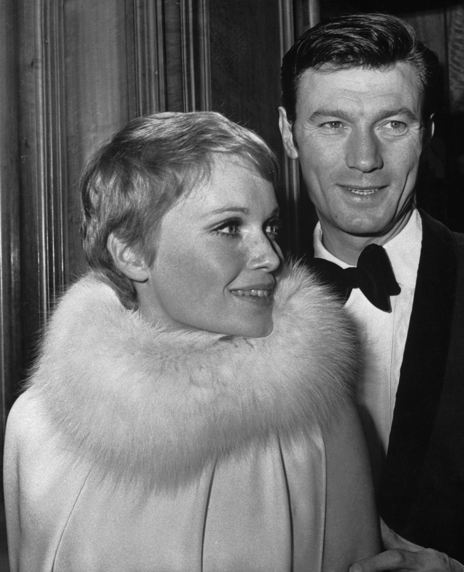 Mia farrow in a fur trim cape dress with laurence harvey at the odeon in london 1967