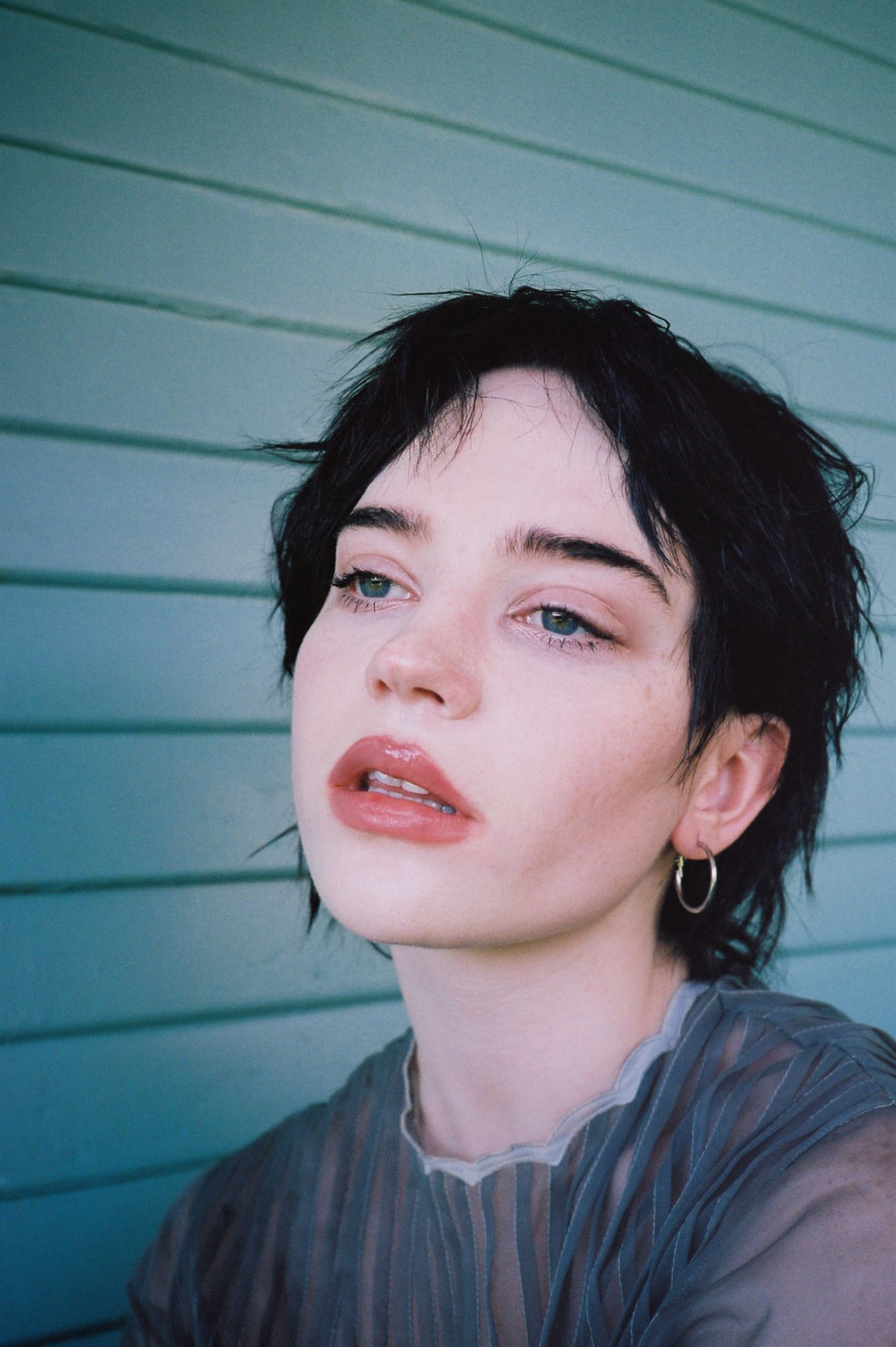 Portrait of Yellowjackets star Sophie Thatcher photographed by Miriam Marlene in front of a painted shed