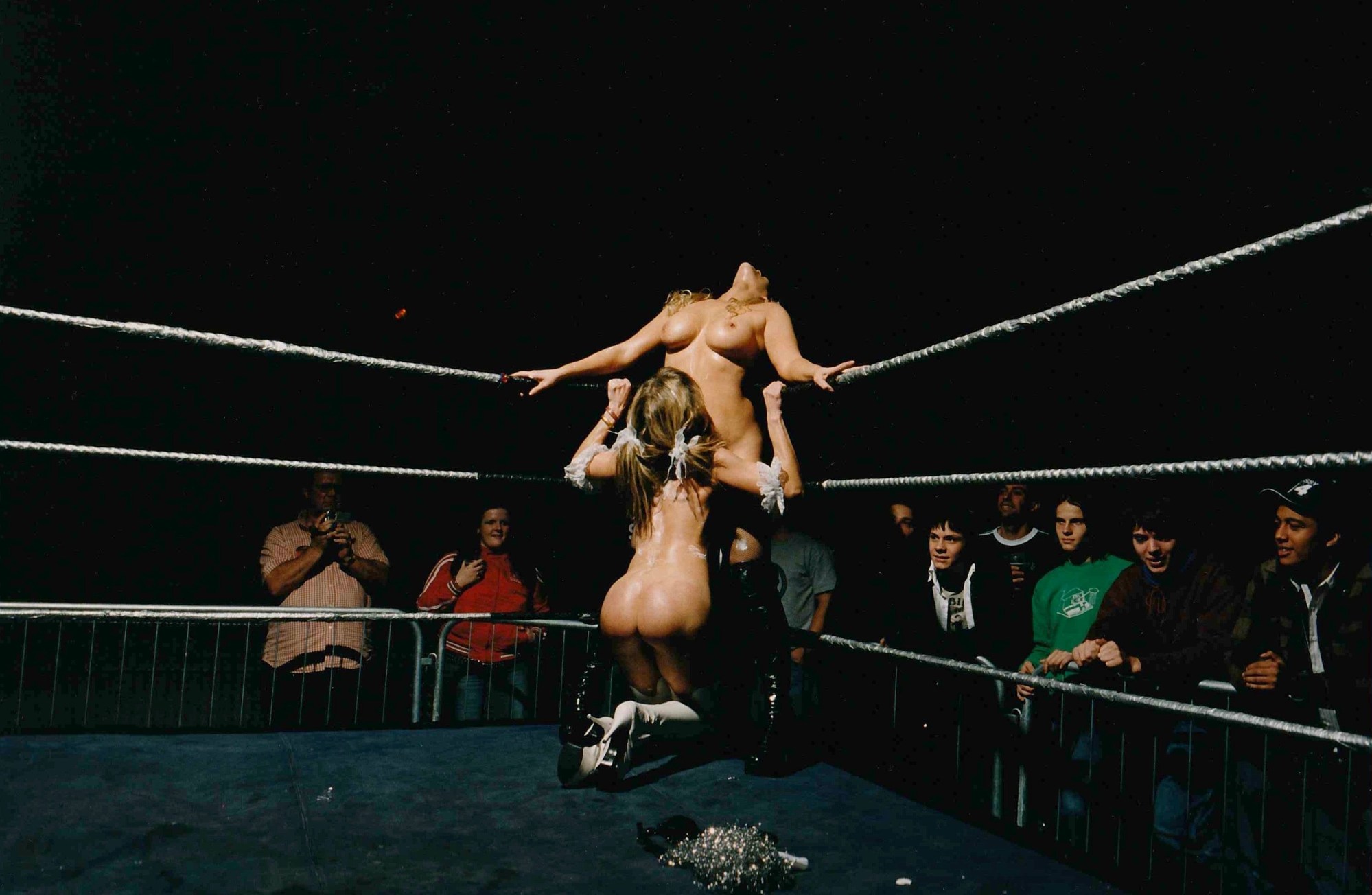 Two naked women perform in a wrestling ring