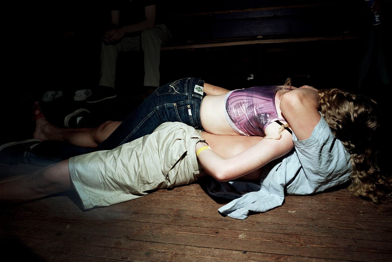 A couple embrace lying on the floor at a party