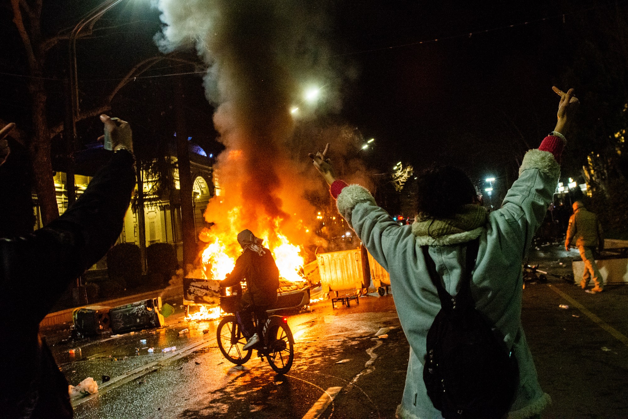 Protestors gather in front of a fire in Tbilisi, Georgia