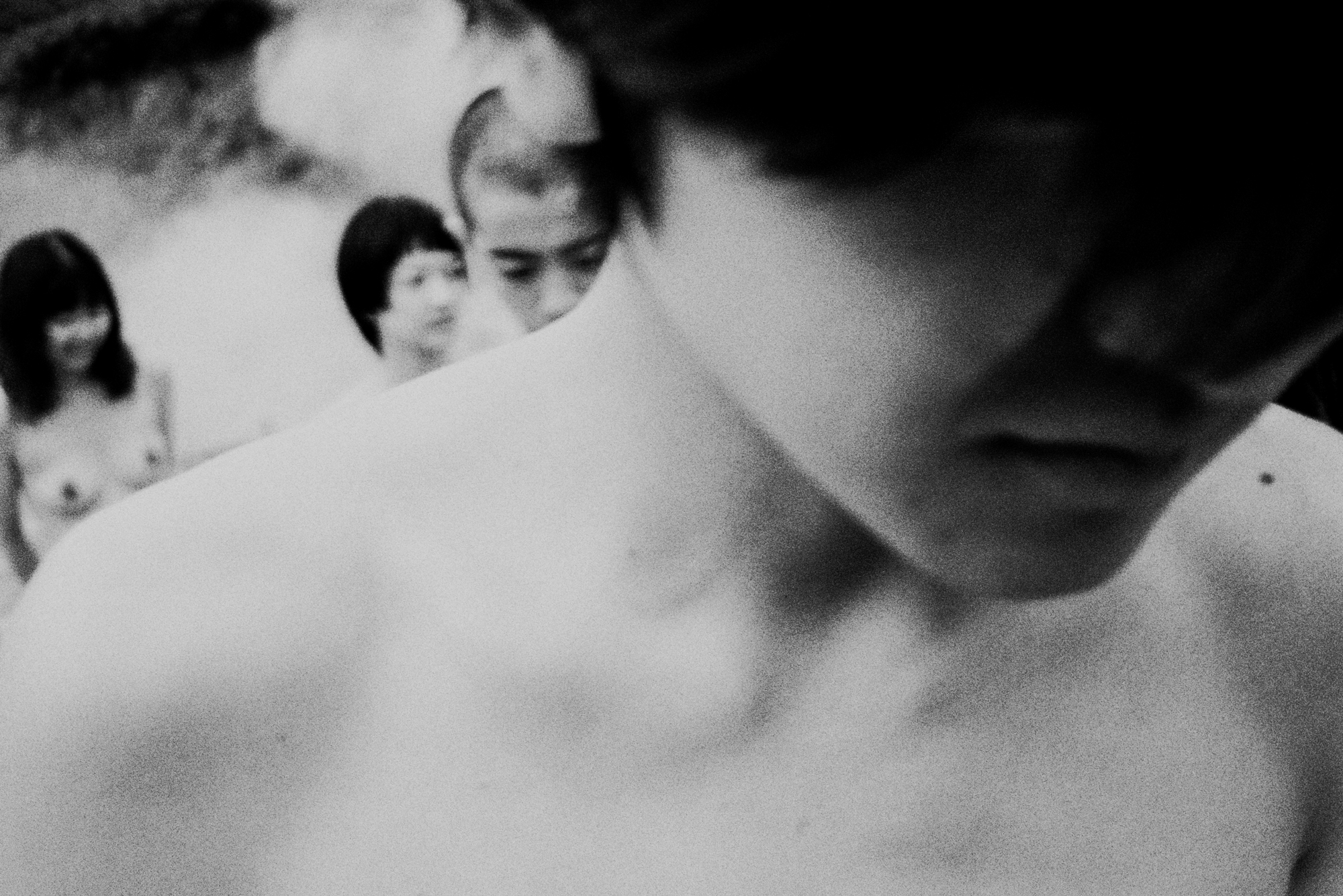 Close up black-and-white image of naked people at a Japanese wild hot spring