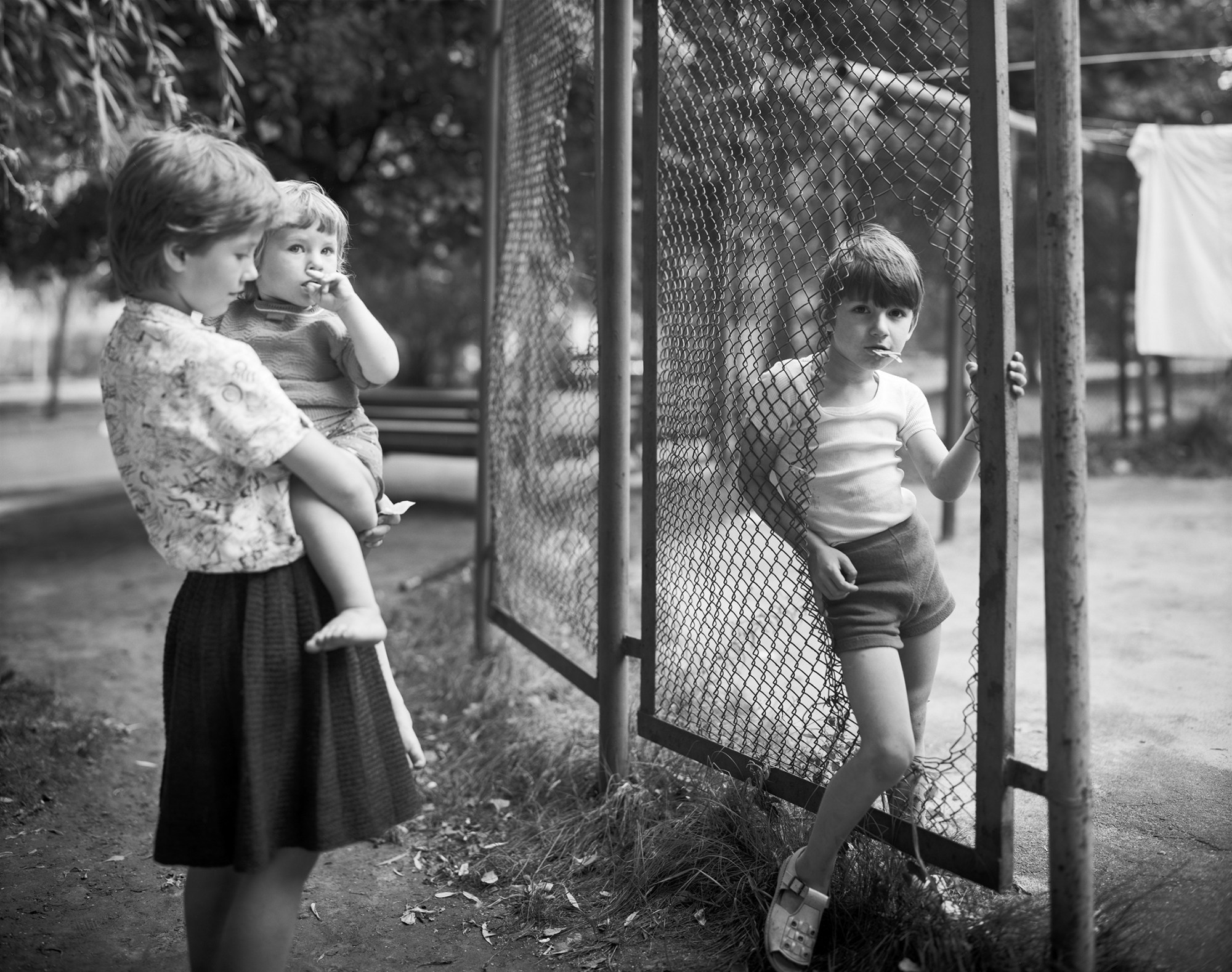 Black-and-white image of three children in a park