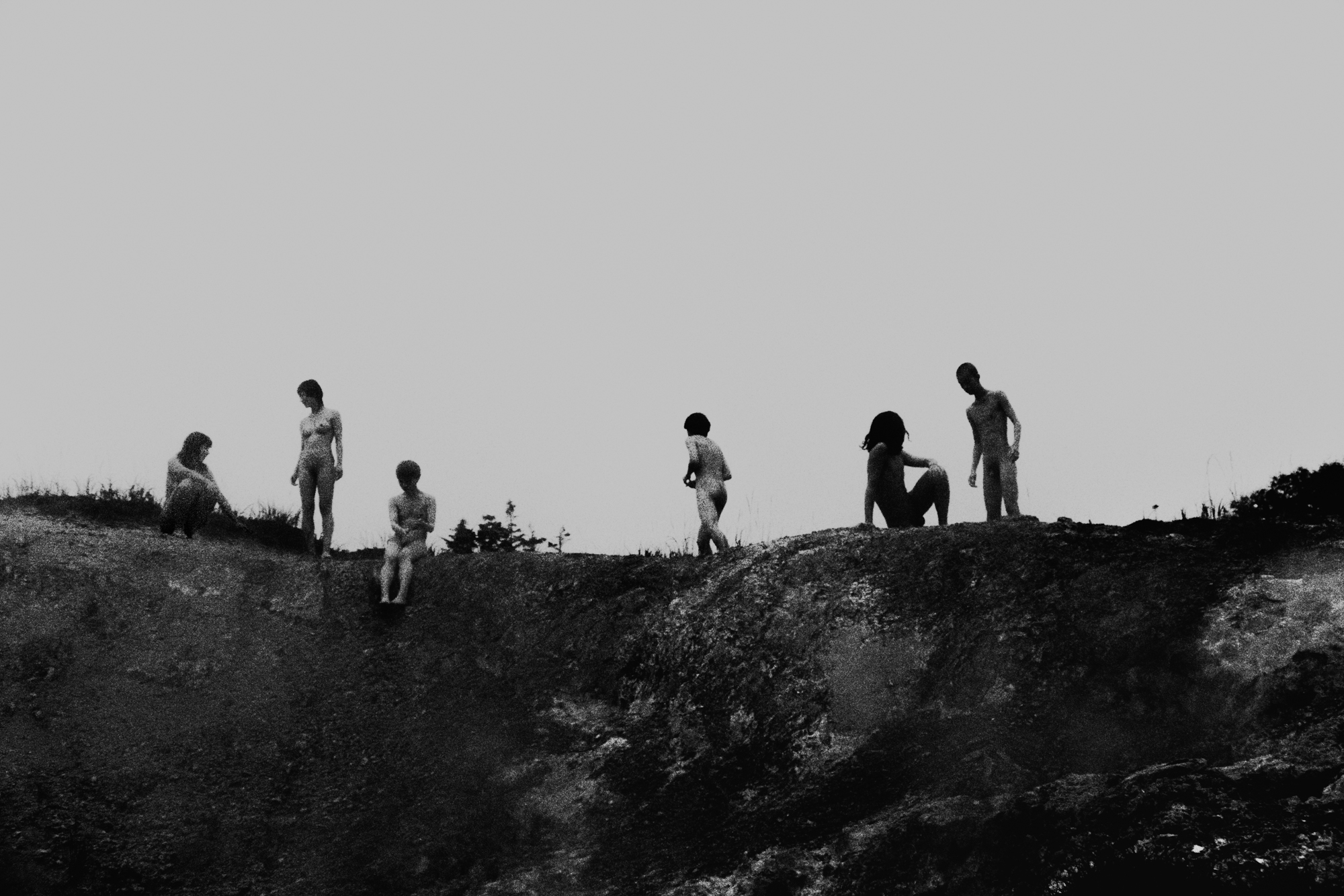 Landscape of a Japanese hot spring, with naked people in the distance walking towards the water