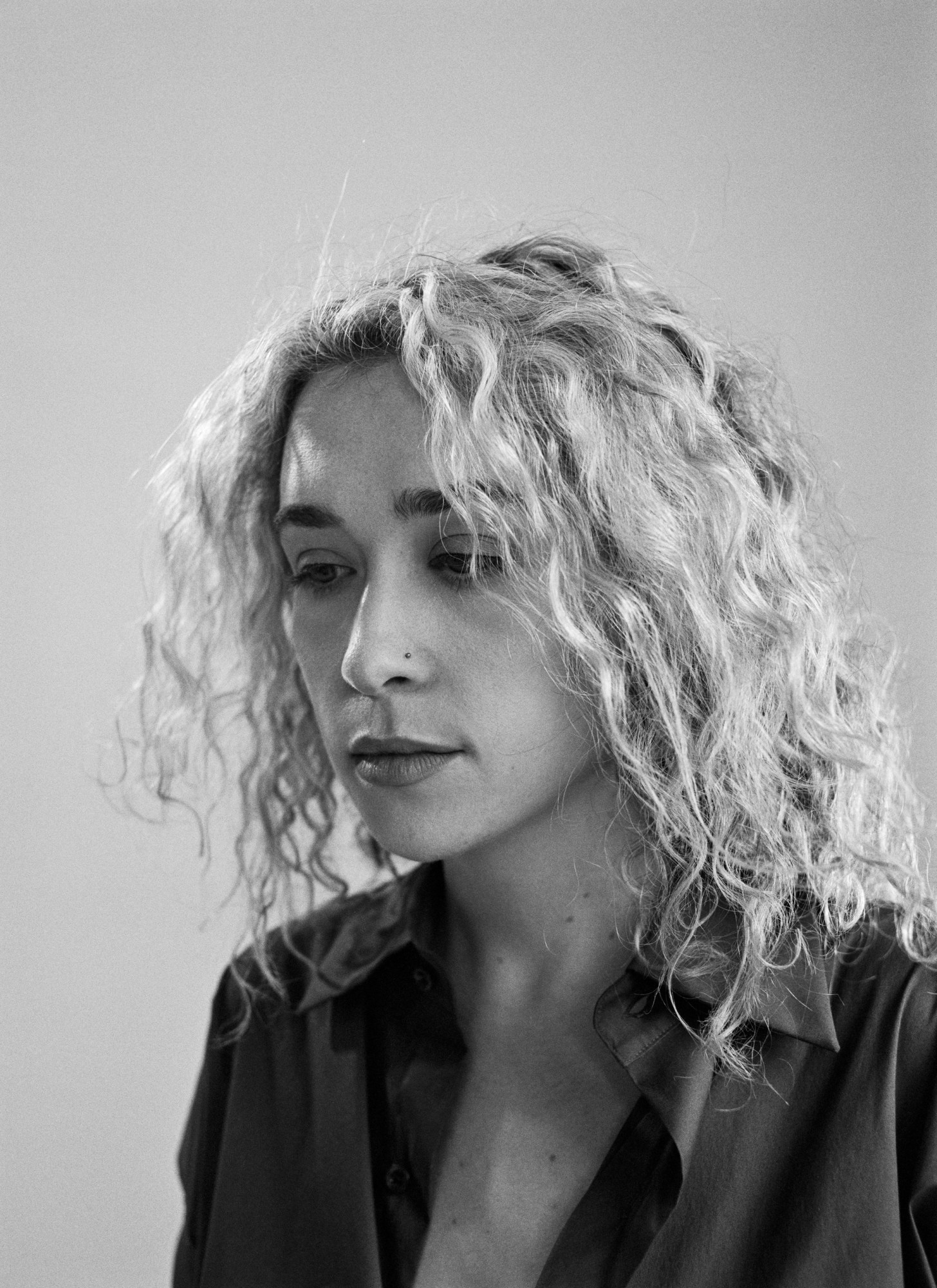 black and white close up portrait of blondshell looking down in a collared shirt